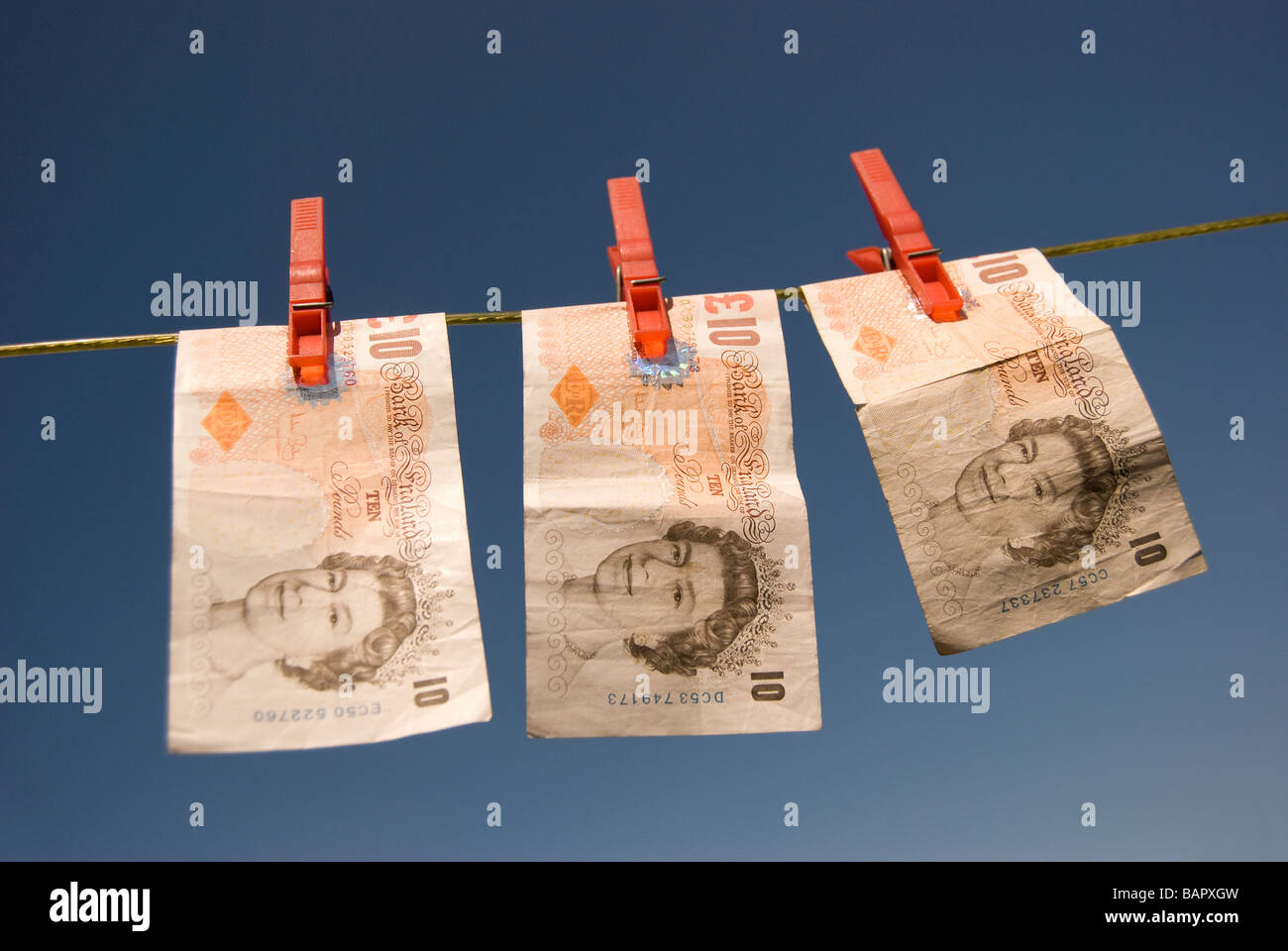 Tre dieci pound note su una linea di lavaggio Foto Stock