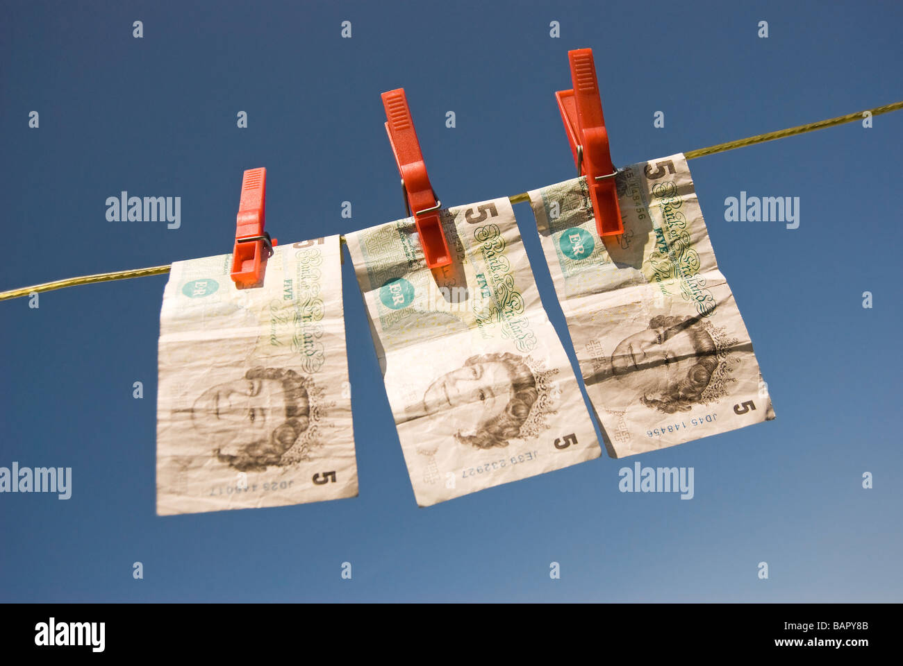 Tre Cinque pound note su una linea di lavaggio Foto Stock