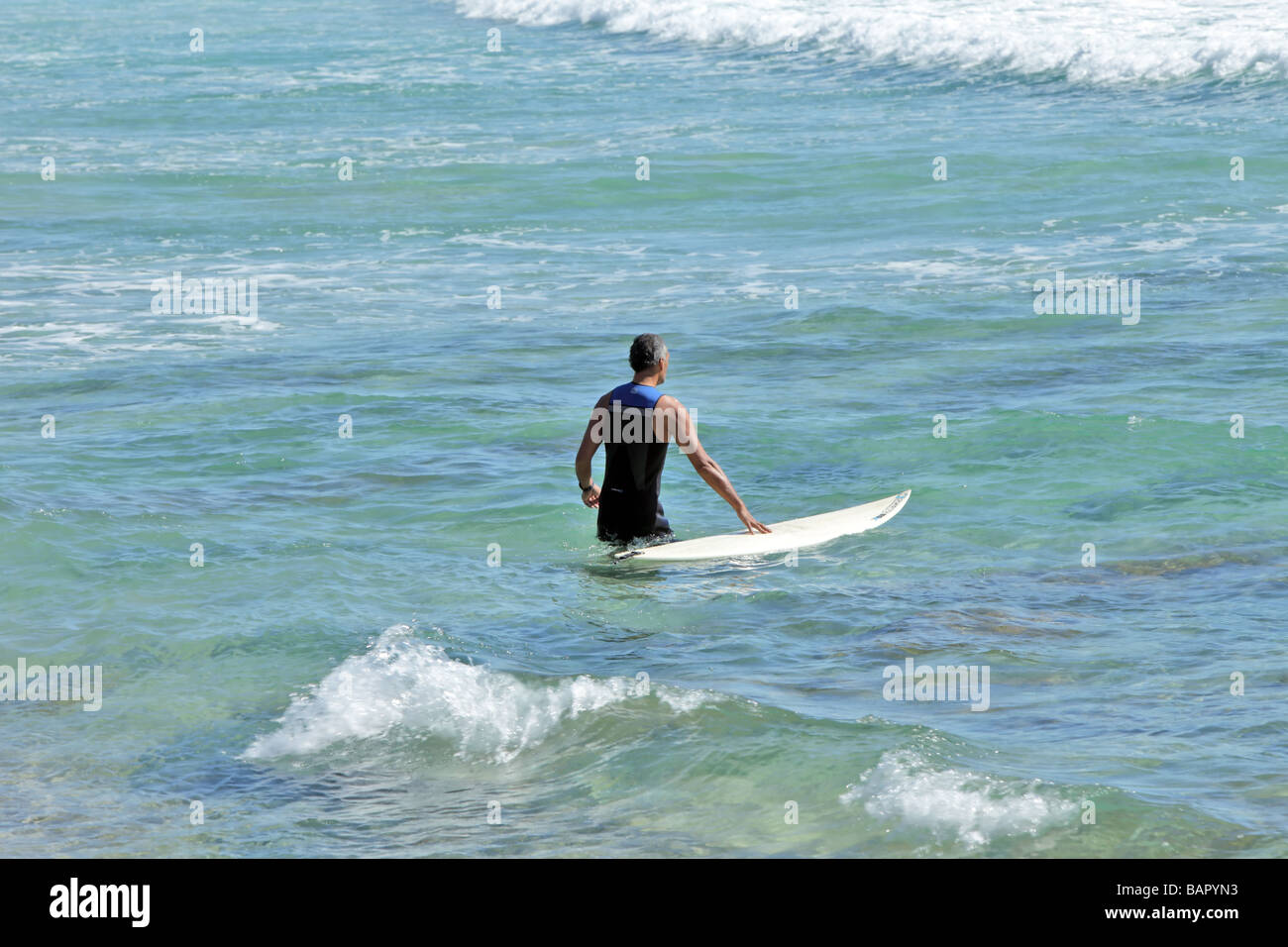 Surfista singolo con una scheda Rubrica fuori per catturare le onde Foto Stock