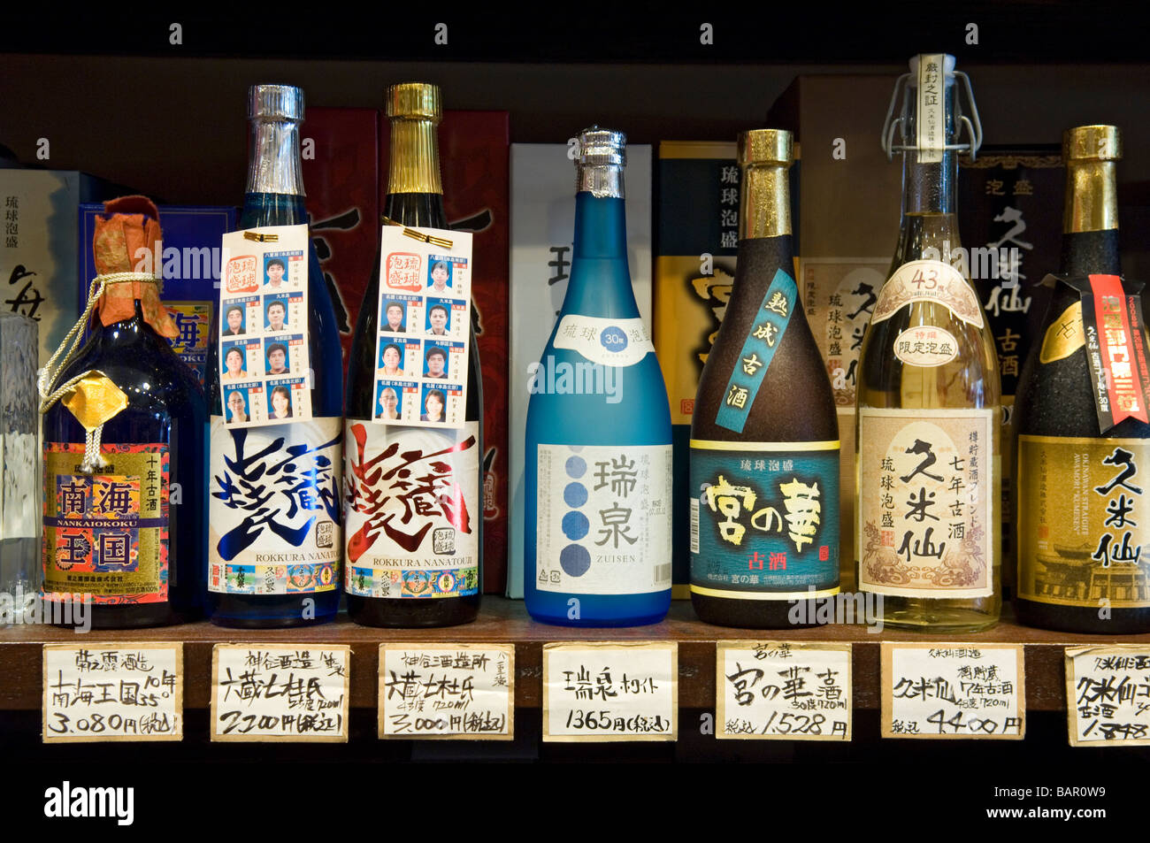 Bottiglie di Sake sul display in uno dei molti turisti in negozi di souvenir in Heiwa Dori mercato. Naha, Okinawa, in Giappone Foto Stock