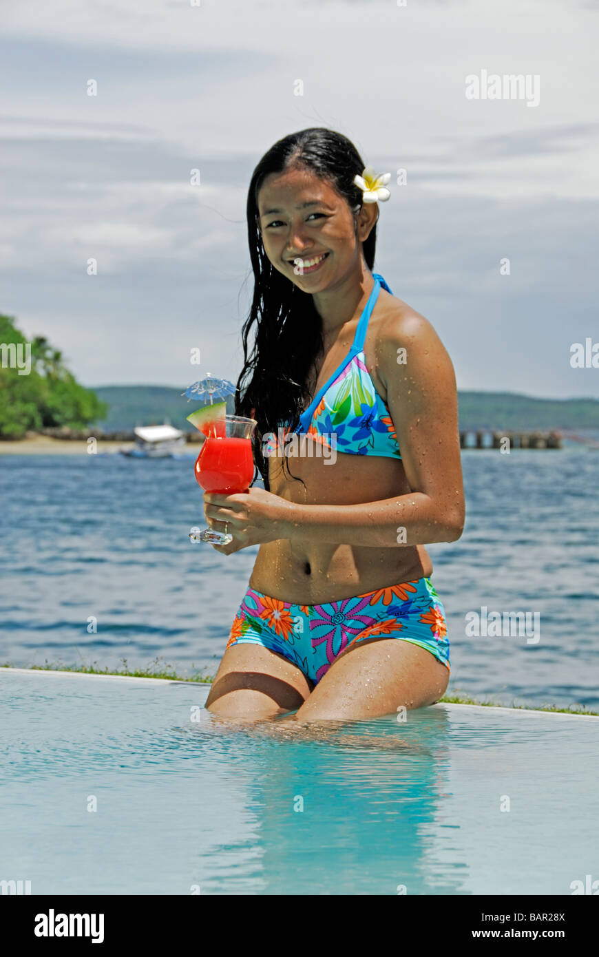 Ragazza sorridente bikini piscina infinity cocktail il Pearl Farm Resort, Samal Island Filippine Asia Foto Stock