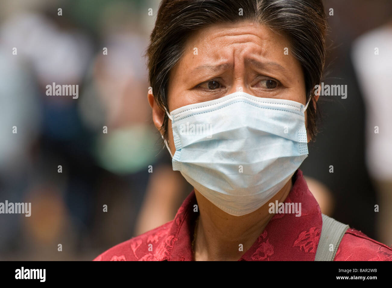 Una donna che indossa una maschera chirurgica come protezione contro l influenza suina Hong Kong Maggio 2009 Foto Stock