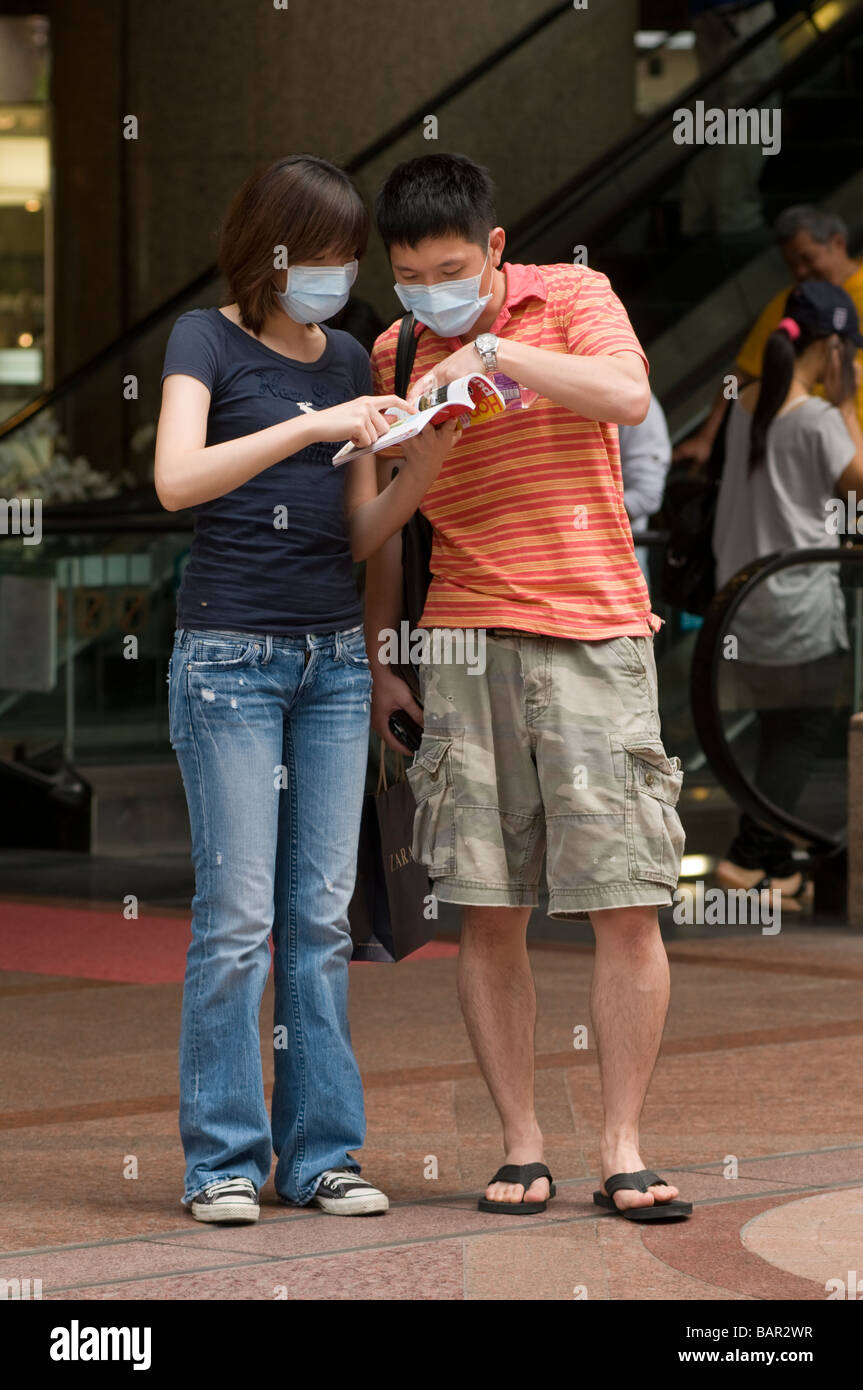 I turisti indossare maschere chirurgiche come protezione contro l influenza suina Hong Kong Maggio 2009 Foto Stock