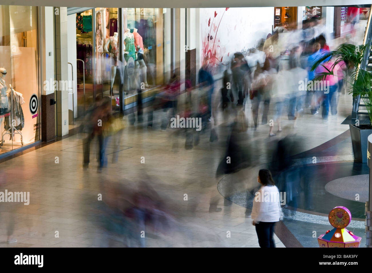 Lonely shopper si distingue da tutti gli altri durante la sincronizzazione posteriore flash fotografia nel Overgate shopping mall a Dundee, Regno Unito Foto Stock