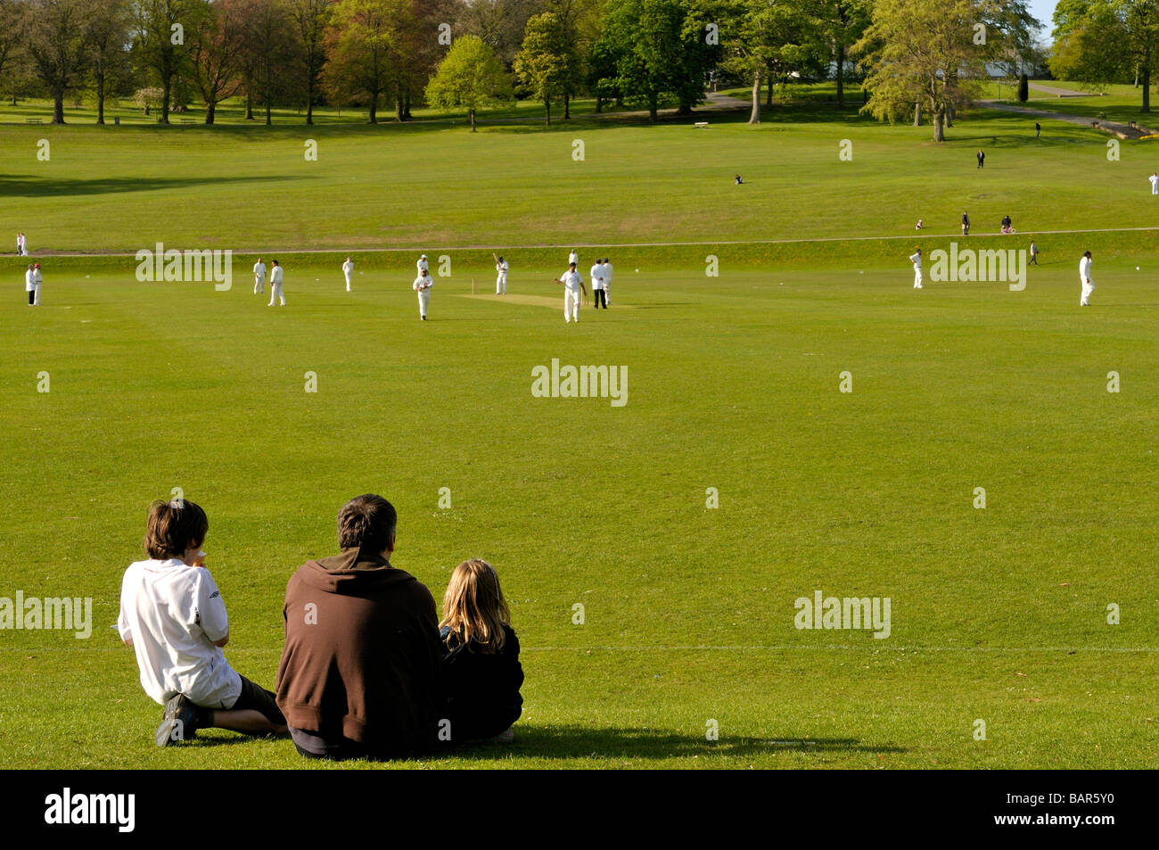 Famiglia guardare il cricket pratica a Roundhay Park Leeds West Yorkshire Inghilterra Foto Stock