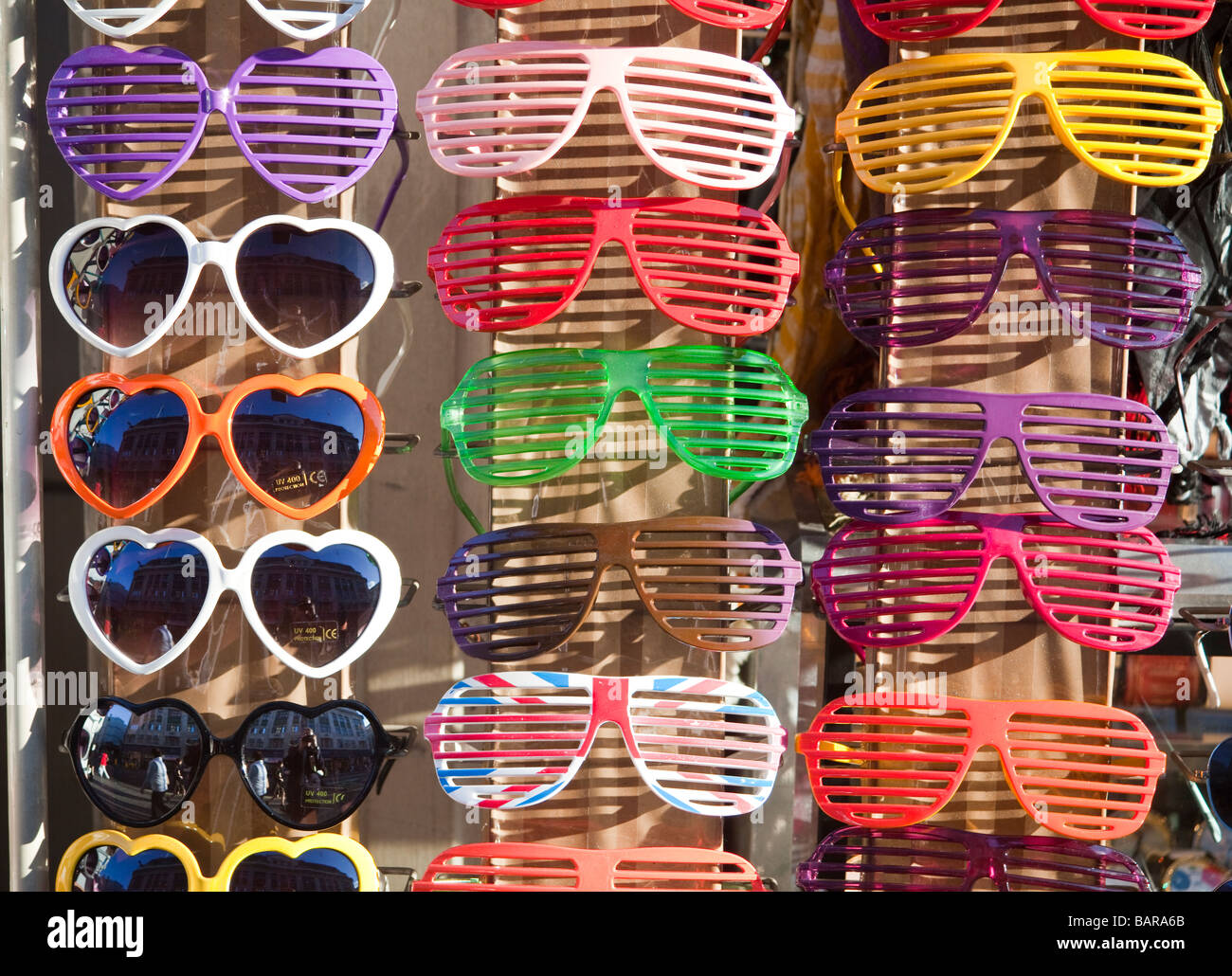 Occhiali da sole colorati in vendita in shopfront, Oxfofrd, Street, Londra, Inghilterra Foto Stock