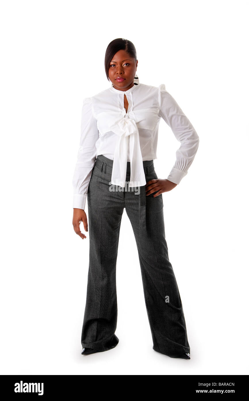 Bella African American Business donna con atteggiamento duro vestito con una camicia bianca e pantaloni grigi isolato permanente Foto Stock