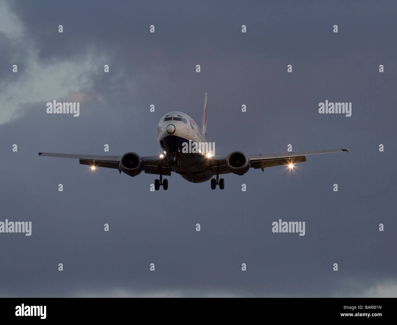 British Airways Boeing 737-400 jet aereo in arrivo in un cielo nuvoloso al tramonto Foto Stock