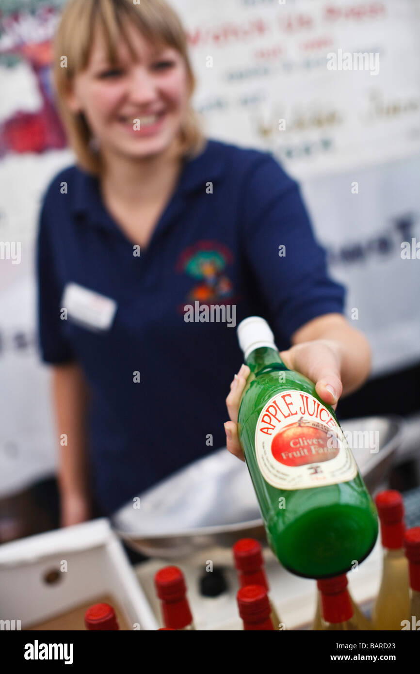 Donna vendita di succo di mela in una fattoria di mercato, REGNO UNITO Foto Stock