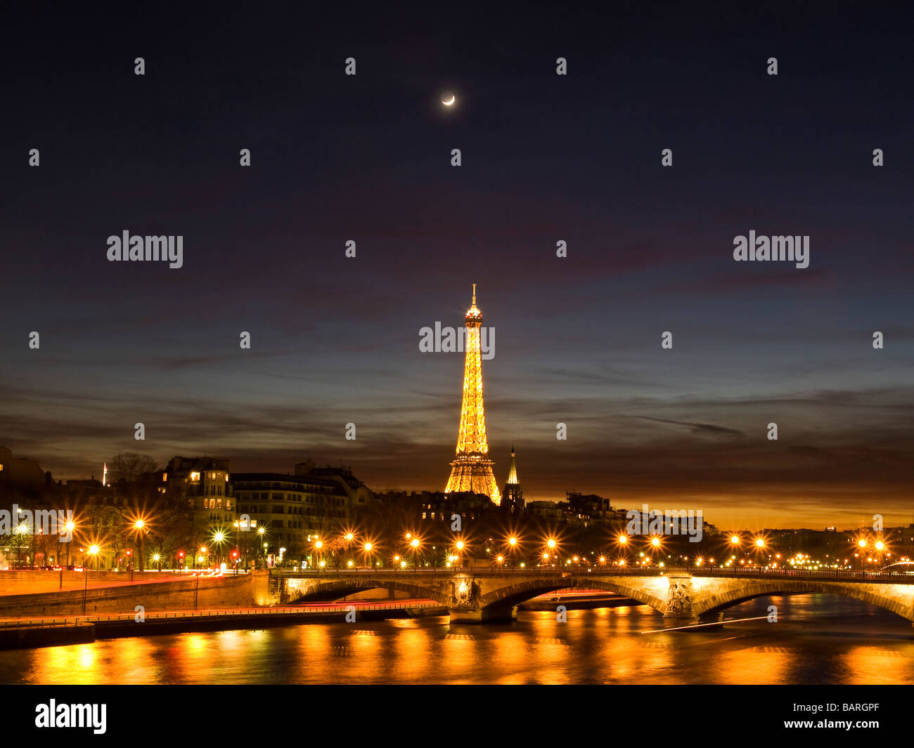 Torre Eiffel durante la notte con le luci della città si riflette nel fiume Senna Foto Stock