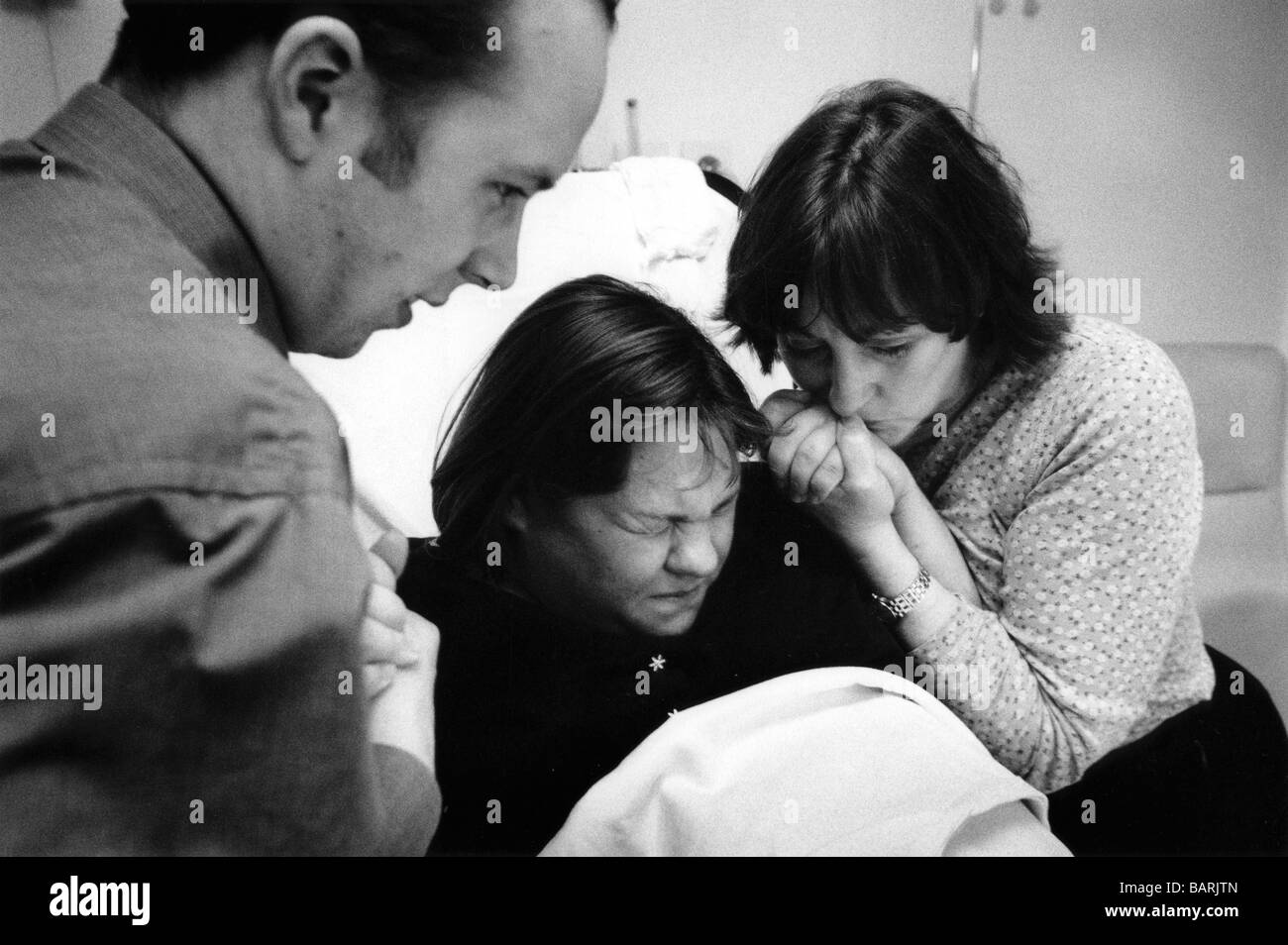 Jenny spinge durante una contrazione. Essa è corredata di sua madre e suo marito durante il suo primo lavoro, Homerton Hospital. Foto Stock