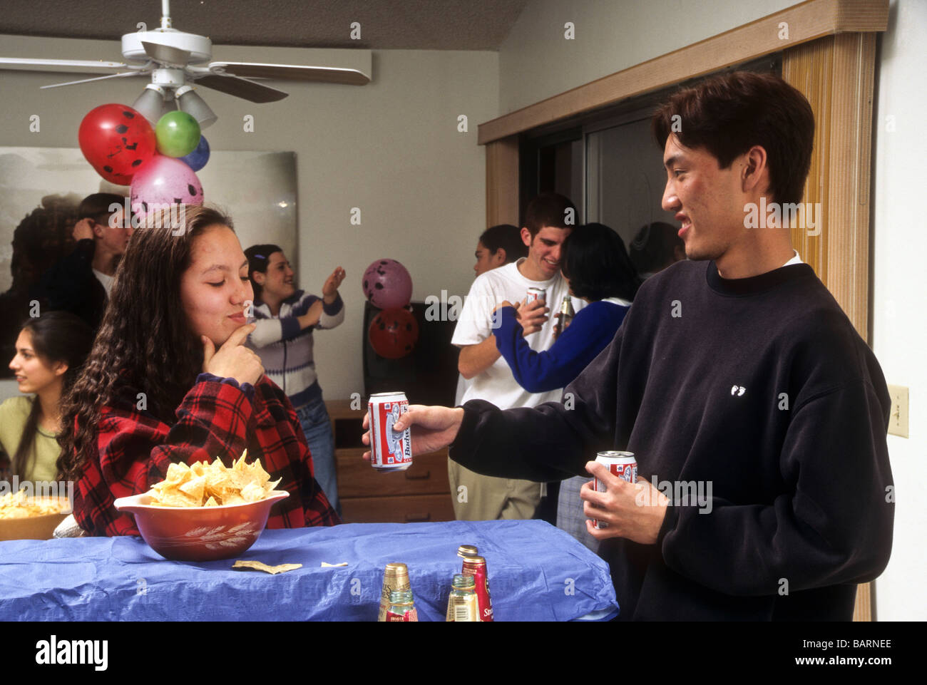 Teen bere alcol birra festa del vino e minorenni booze abuso di droga peer pressure tentare invitare data giovane ragazzo ragazza Foto Stock