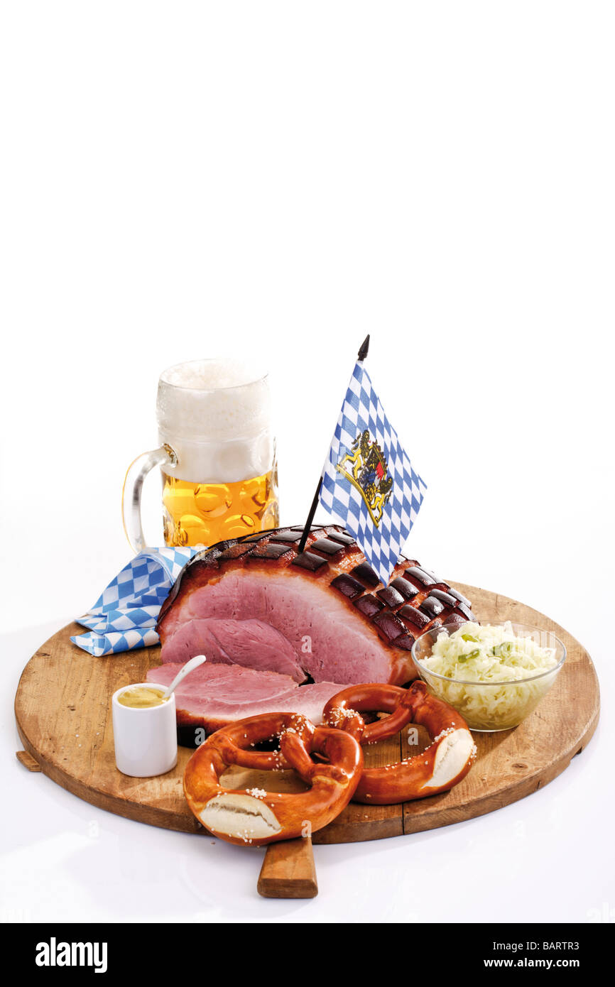 Arrosto di maiale con il crepitio, salatini e un boccale di birra sul pannello di legno Foto Stock
