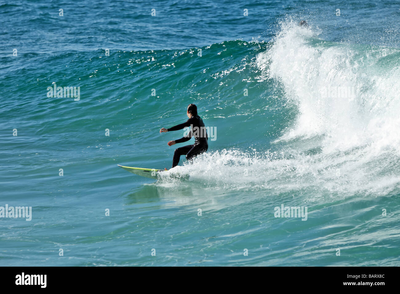 Surfer cavalcare un onda Foto Stock