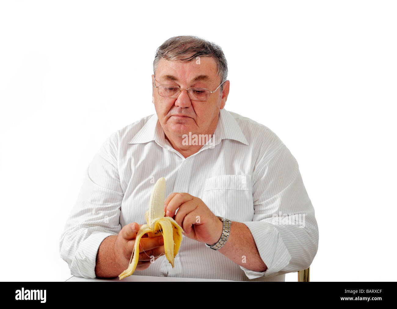Uomo maturo sbucciare una banana Foto Stock