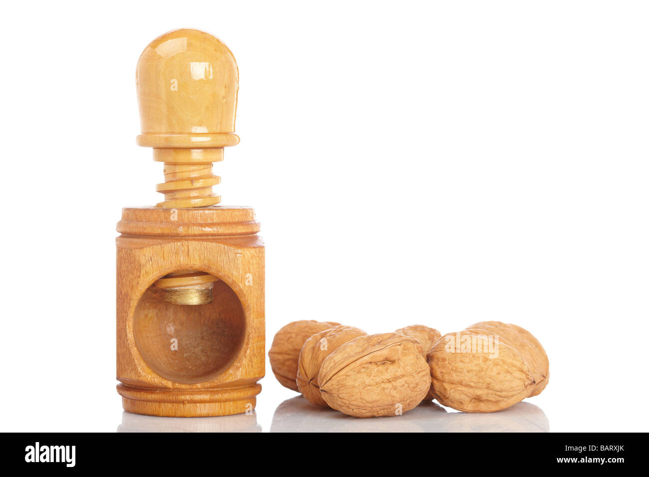 Alcune noci e schiaccianoci di legno riflette su sfondo bianco Foto Stock