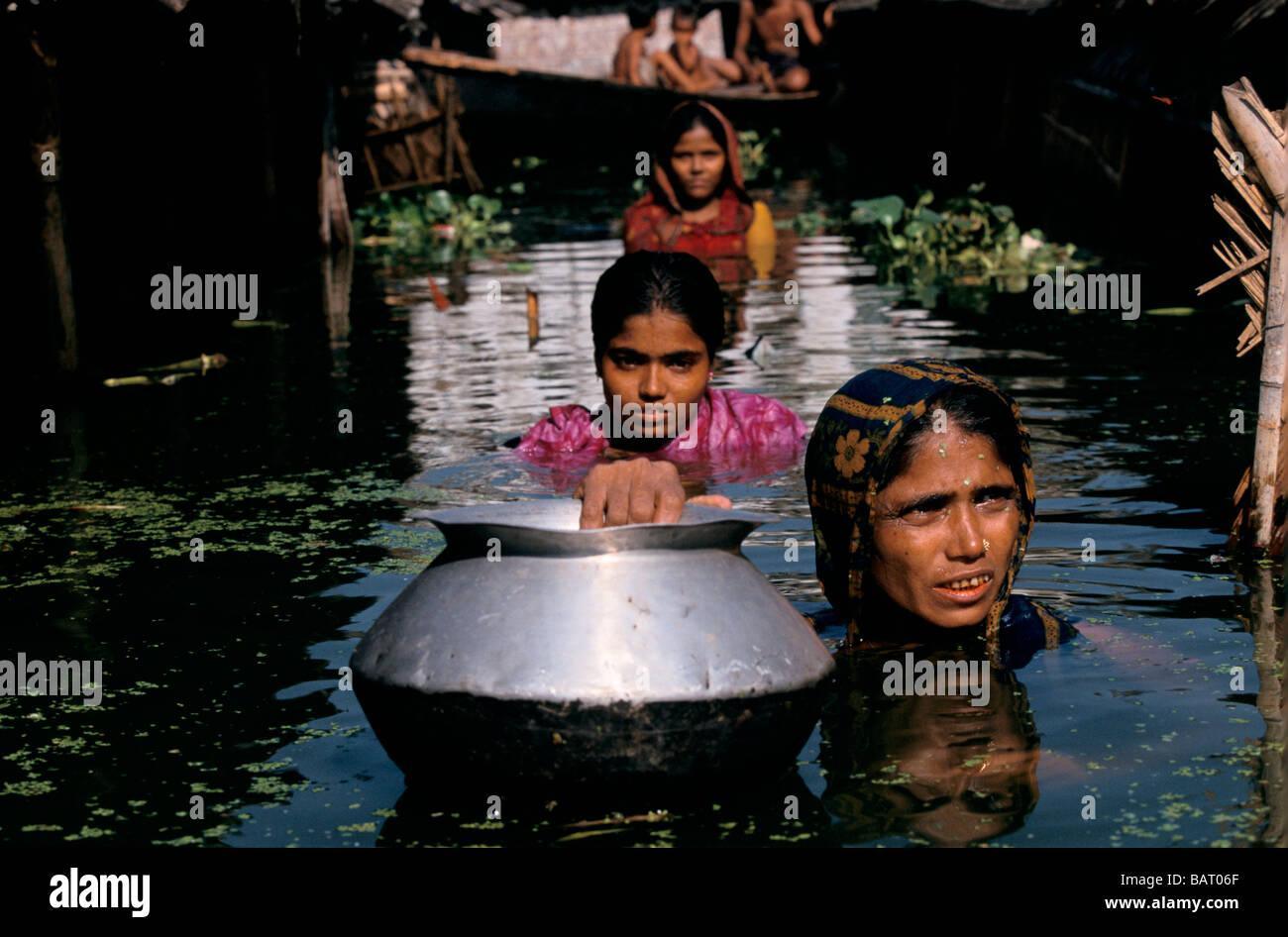 BANGLADESH SETTEMBRE 1998 Madre e figlia nella strada allagata al di fuori della loro casa in Dhakar baraccopoli di Khilgaon Foto Stock