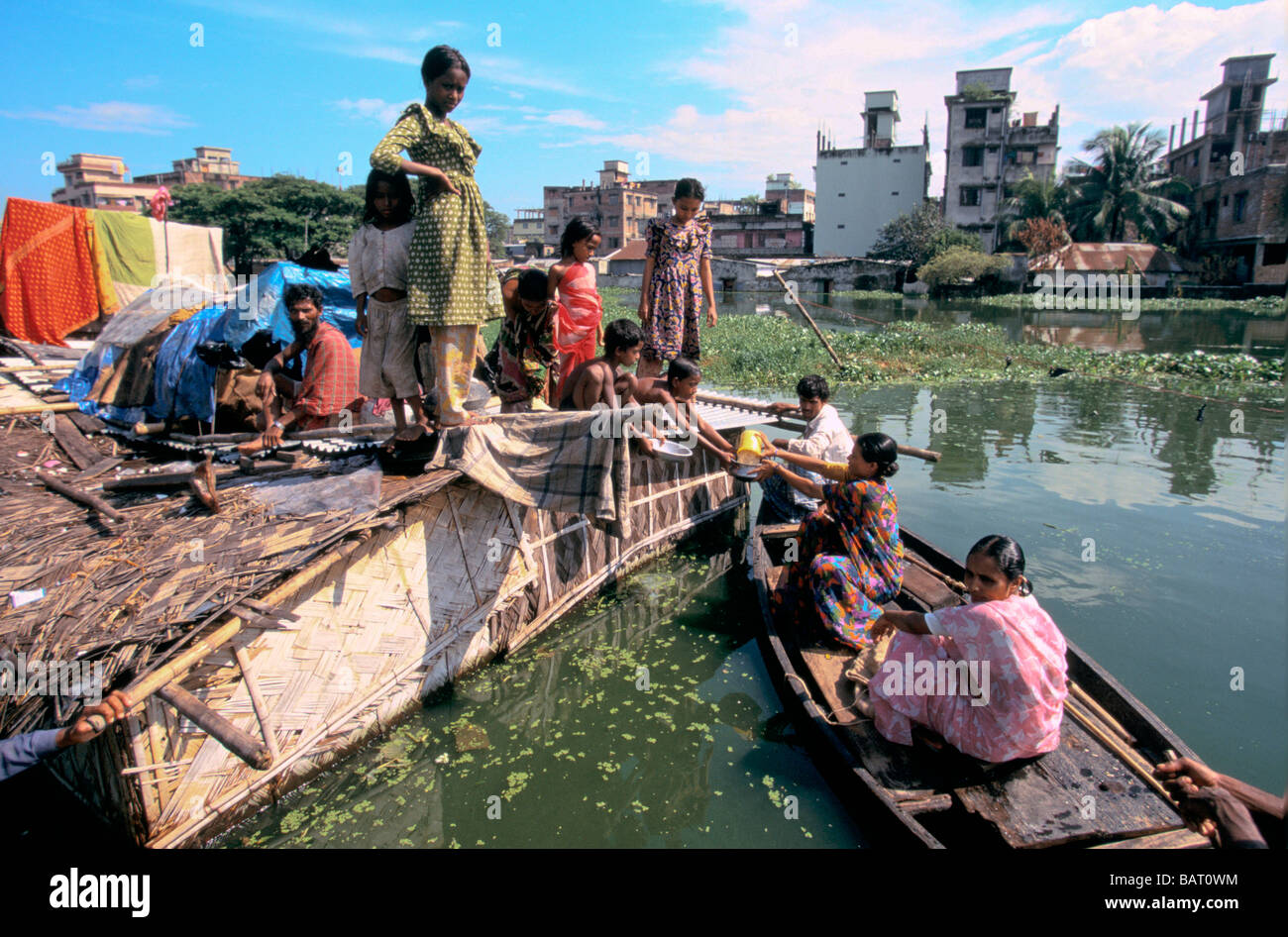 BANGLADESH alluvioni 1998 aiuto agenzia sollievo alimenta ad una famiglia che sono stati intrappolati su tetto 1998 Foto Stock