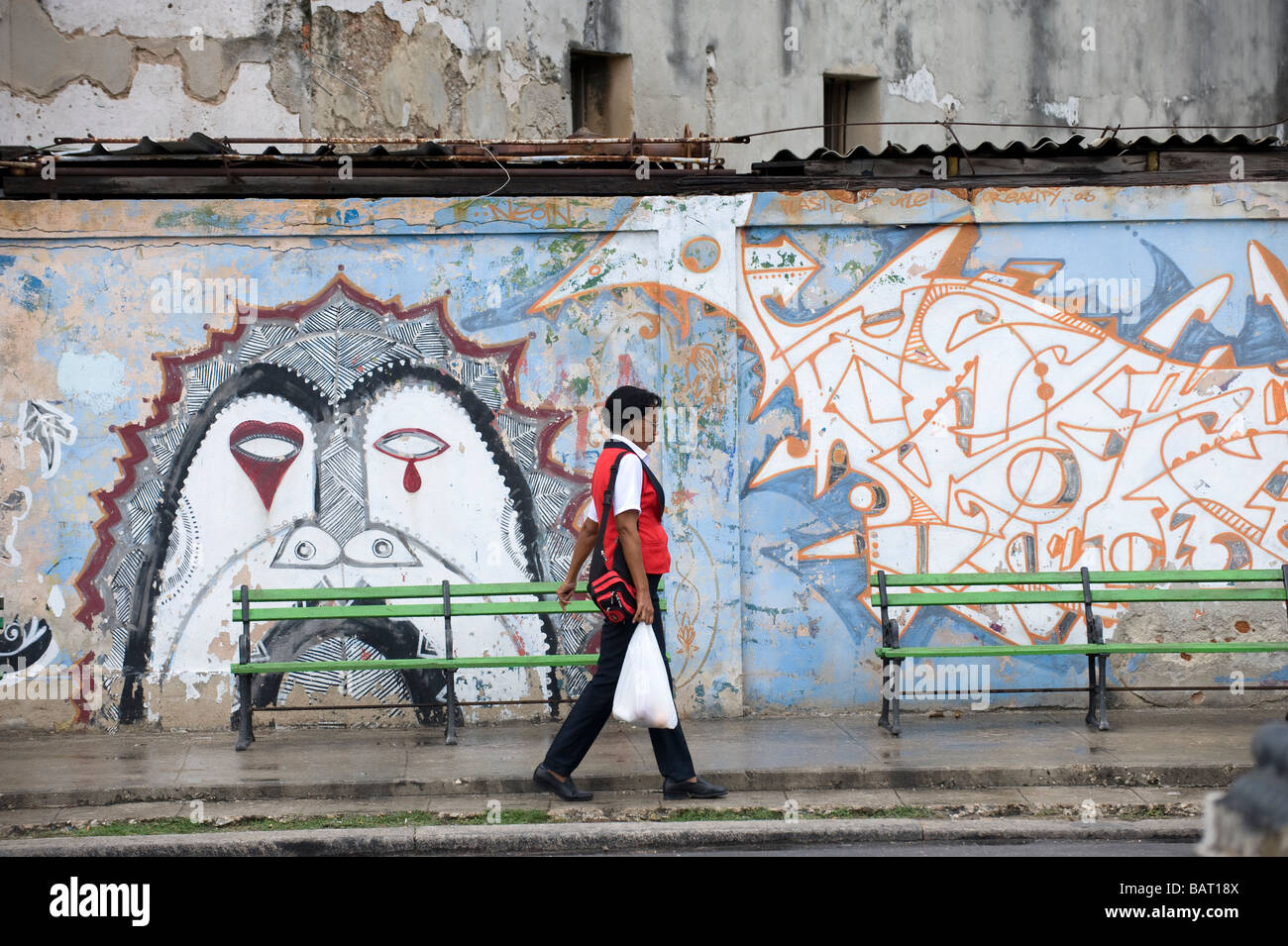 Donna oltrepassando la street art, o gafitti, all Avana, Cuba Foto Stock