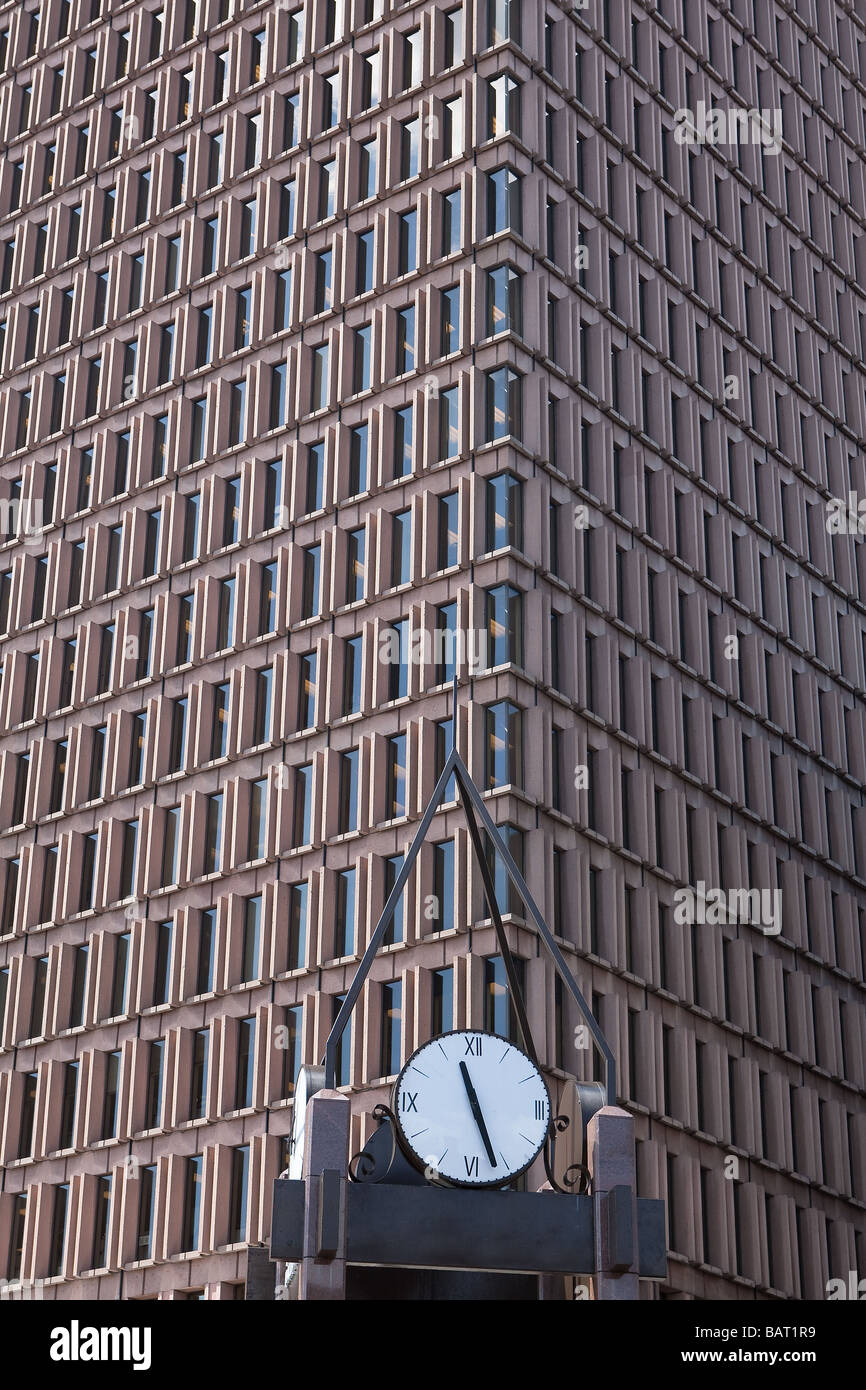 Un orologio di città nella parte anteriore di un grattacielo Foto Stock