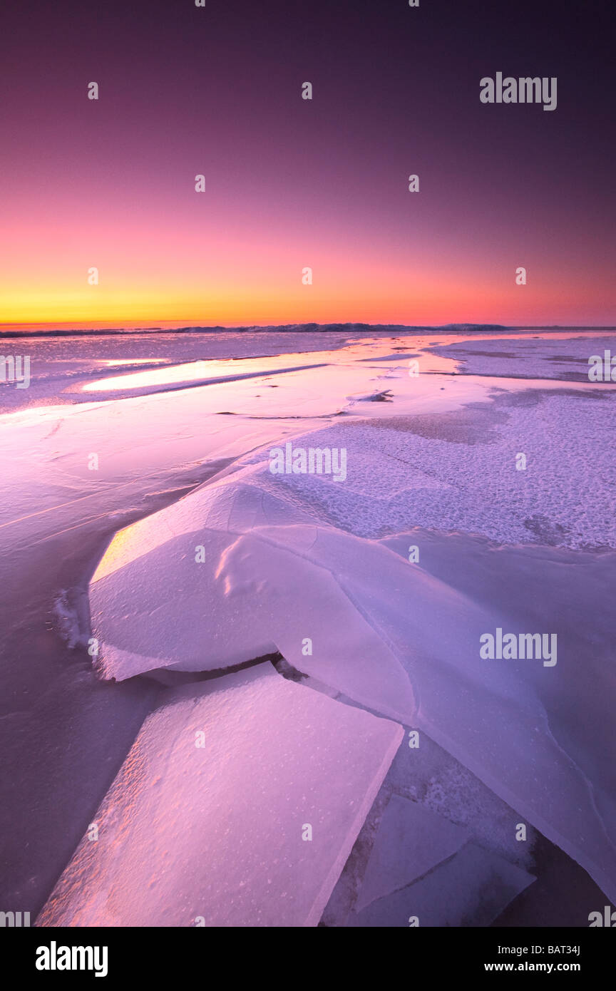 Un lago ghiacciato brilla nel crepuscolo del mattino Foto Stock
