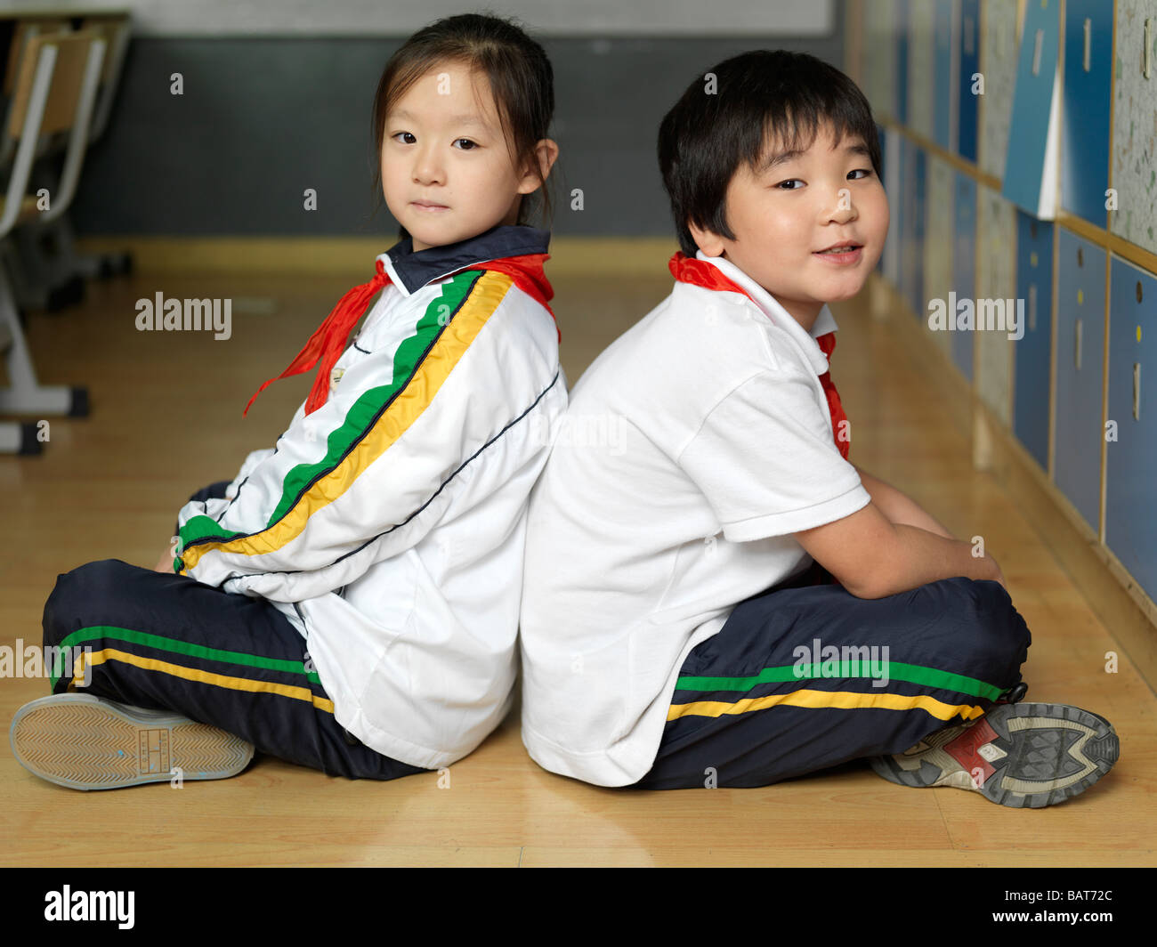 Due compagni di classe seduta in stile-Indiano sul pavimento della loro classe. Foto Stock