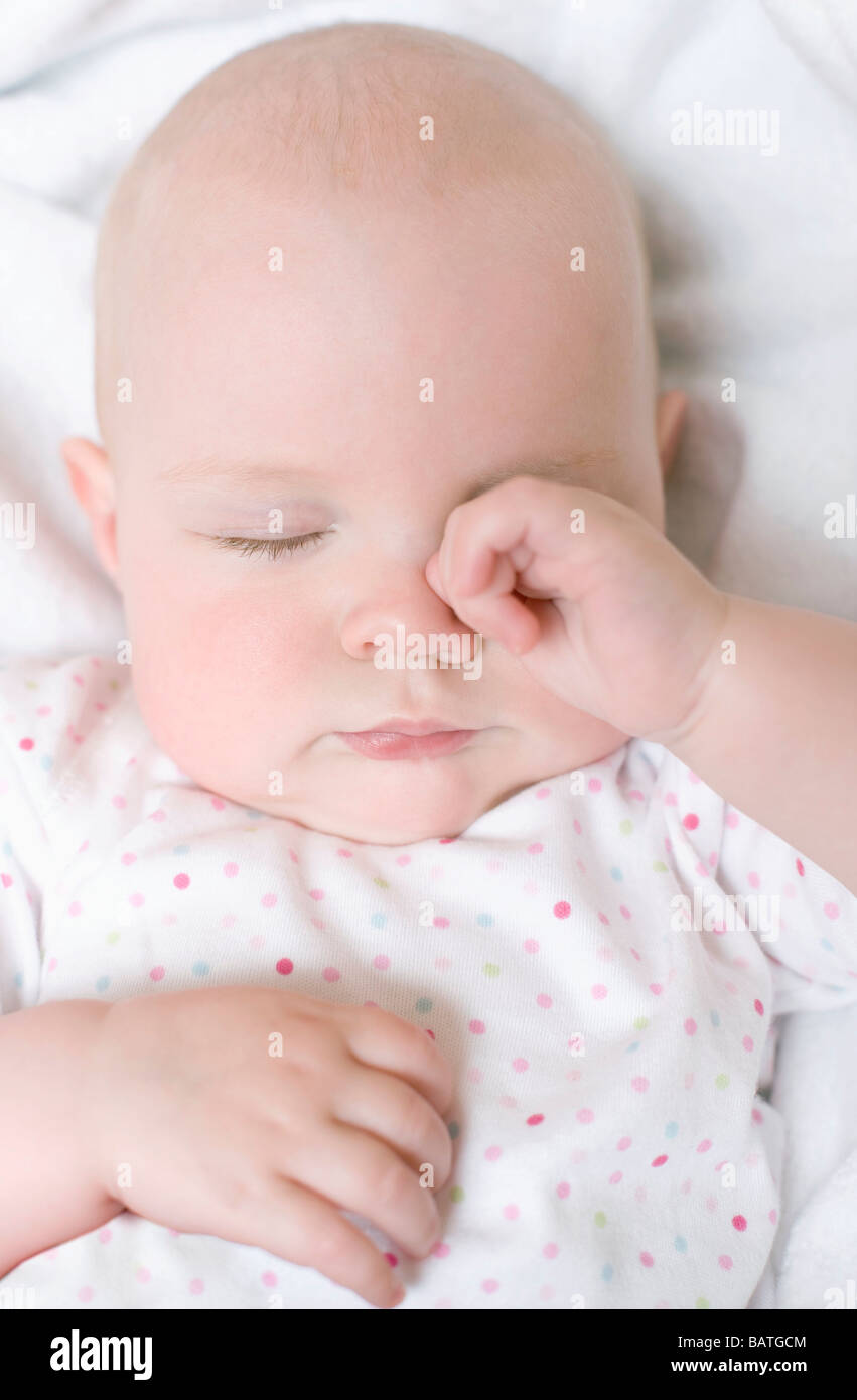 Stanco bambino. 7 mesi Baby girl strofinando il suo occhio. Foto Stock