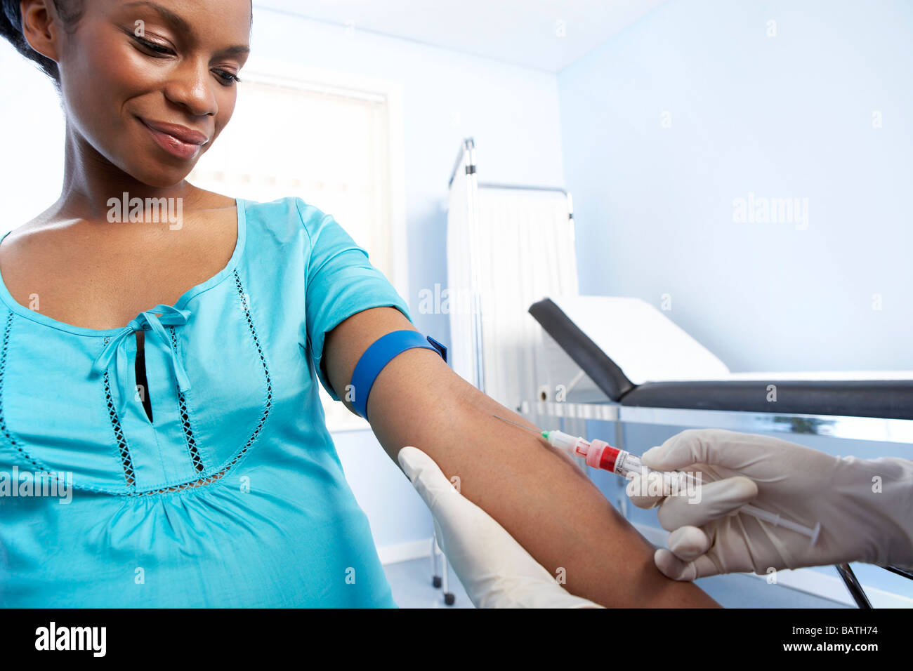 Esame di ostetricia. La levatrice di prendere un campione di sangue dal braccio di una donna in stato di gravidanza. Foto Stock