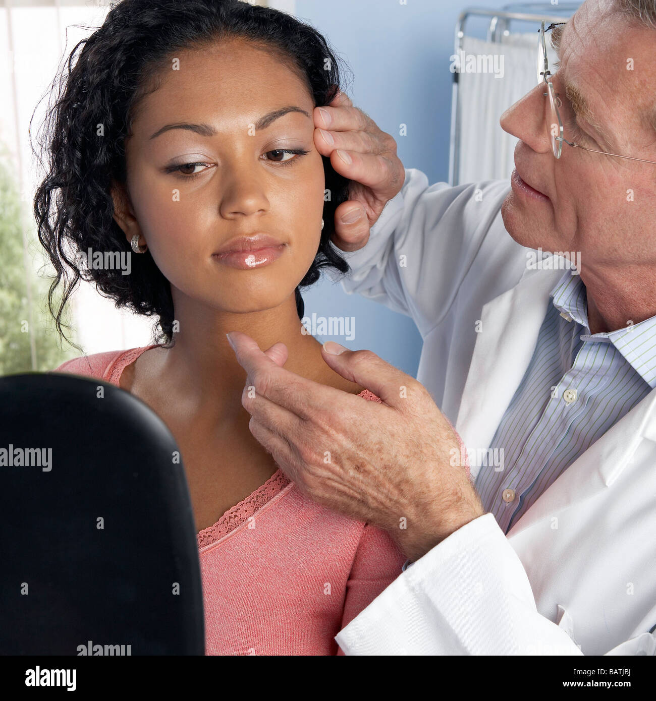 Chirurgia estetica. Consulente di esaminare il volto di una giovane donna contemplando la chirurgia estetica. Foto Stock