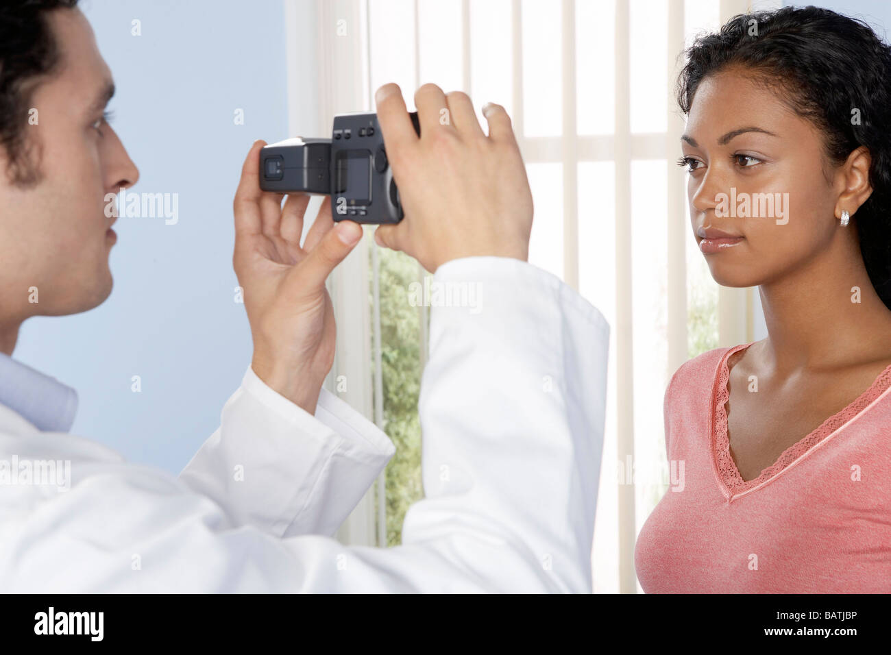 Chirurgia estetica. Consulente prende una fotografia del suo paziente prima che egli subisce interventi di chirurgia estetica. Foto Stock