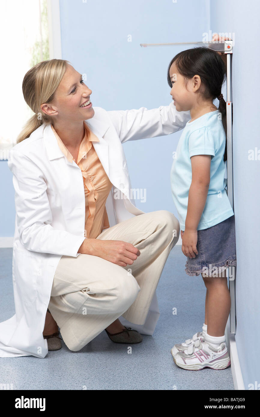 Bambino di misurazione dell'altezza. Medico la misurazione dell'altezza di una giovane ragazza durante un check-up. Foto Stock