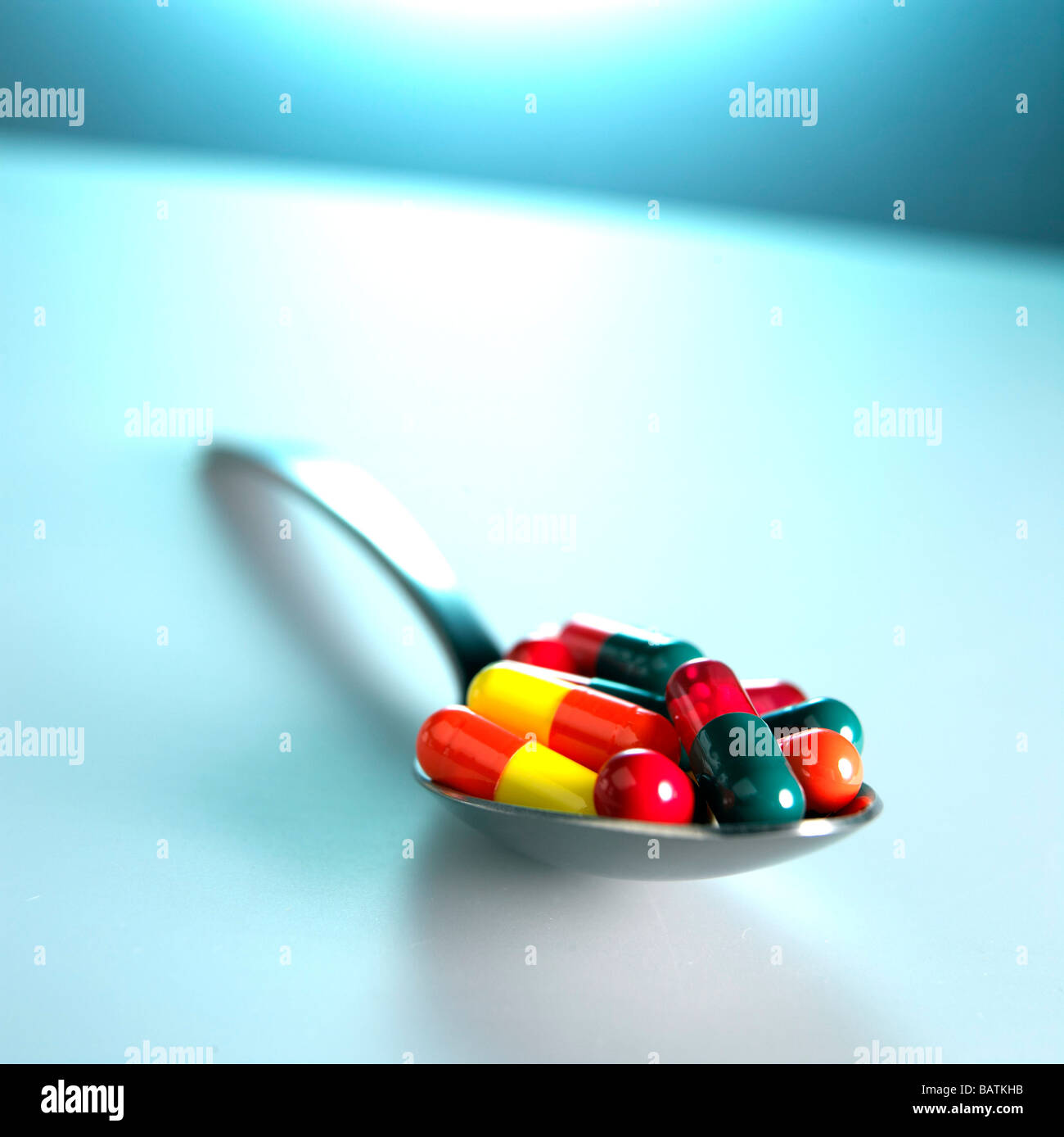 Pillole di vario tipo su un cucchiaio. Questo potrebbe rappresentare un sovradosaggio o la necessità di assumere una varietà di farmaci per il trattamento di una malattia. Foto Stock