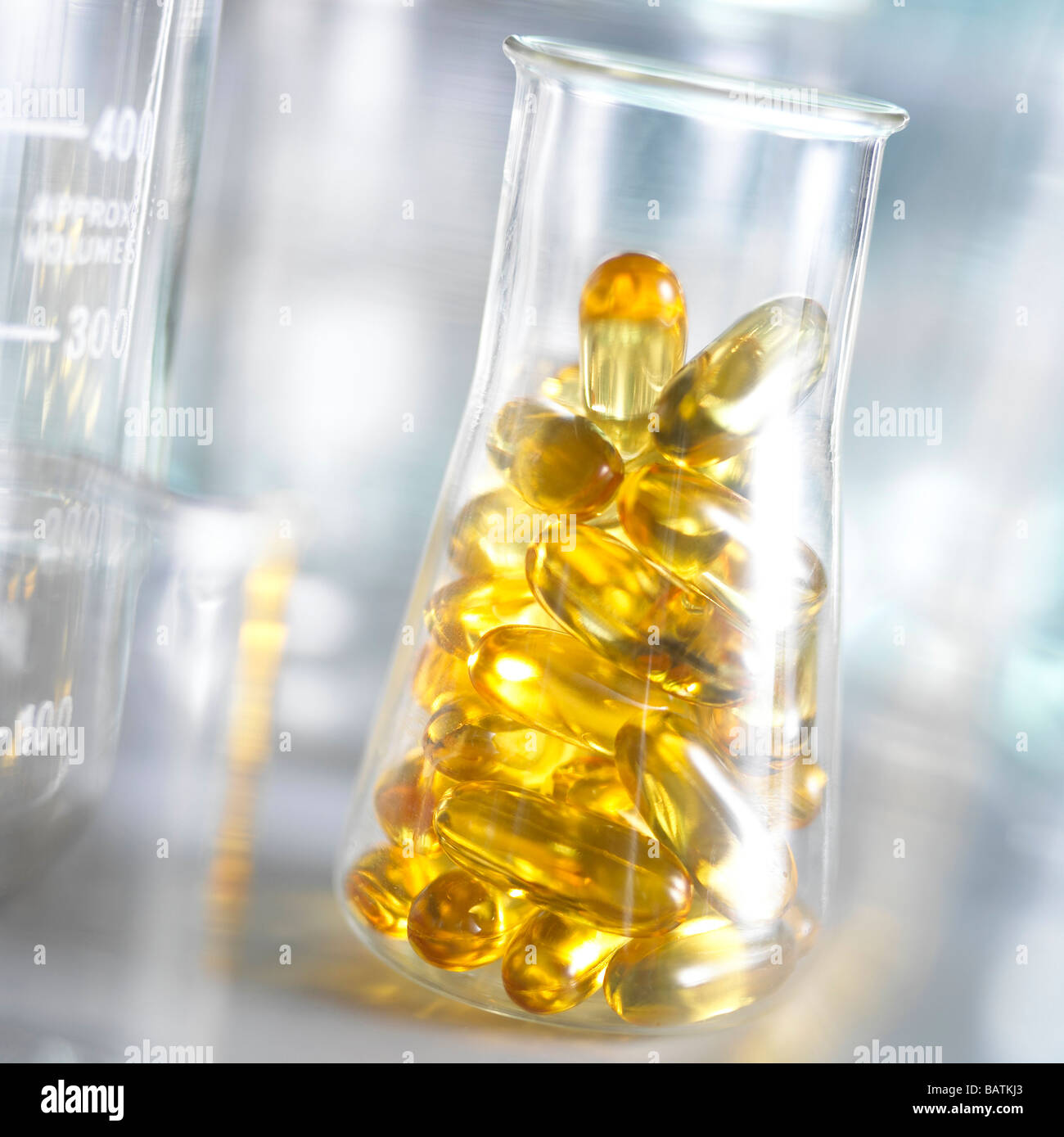 Integrare la ricerca. Olio di fegato di merluzzo capsule in una beuta conica. Questo potrebbe rappresentare la ricerca in alimentazione e nutrizione. Foto Stock