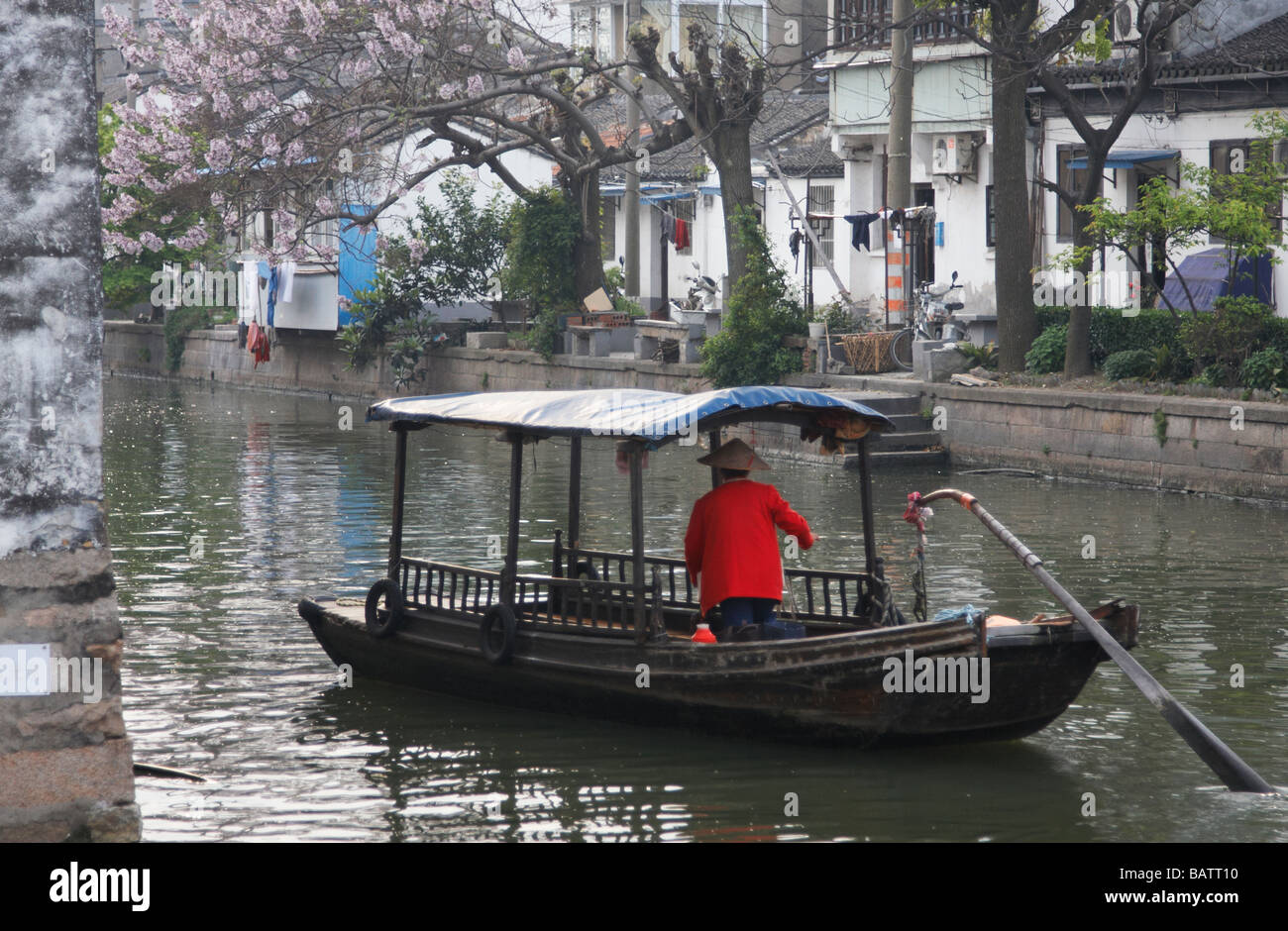 Donna barca sterzo lungo Canal, Suzhou, Cina Foto Stock