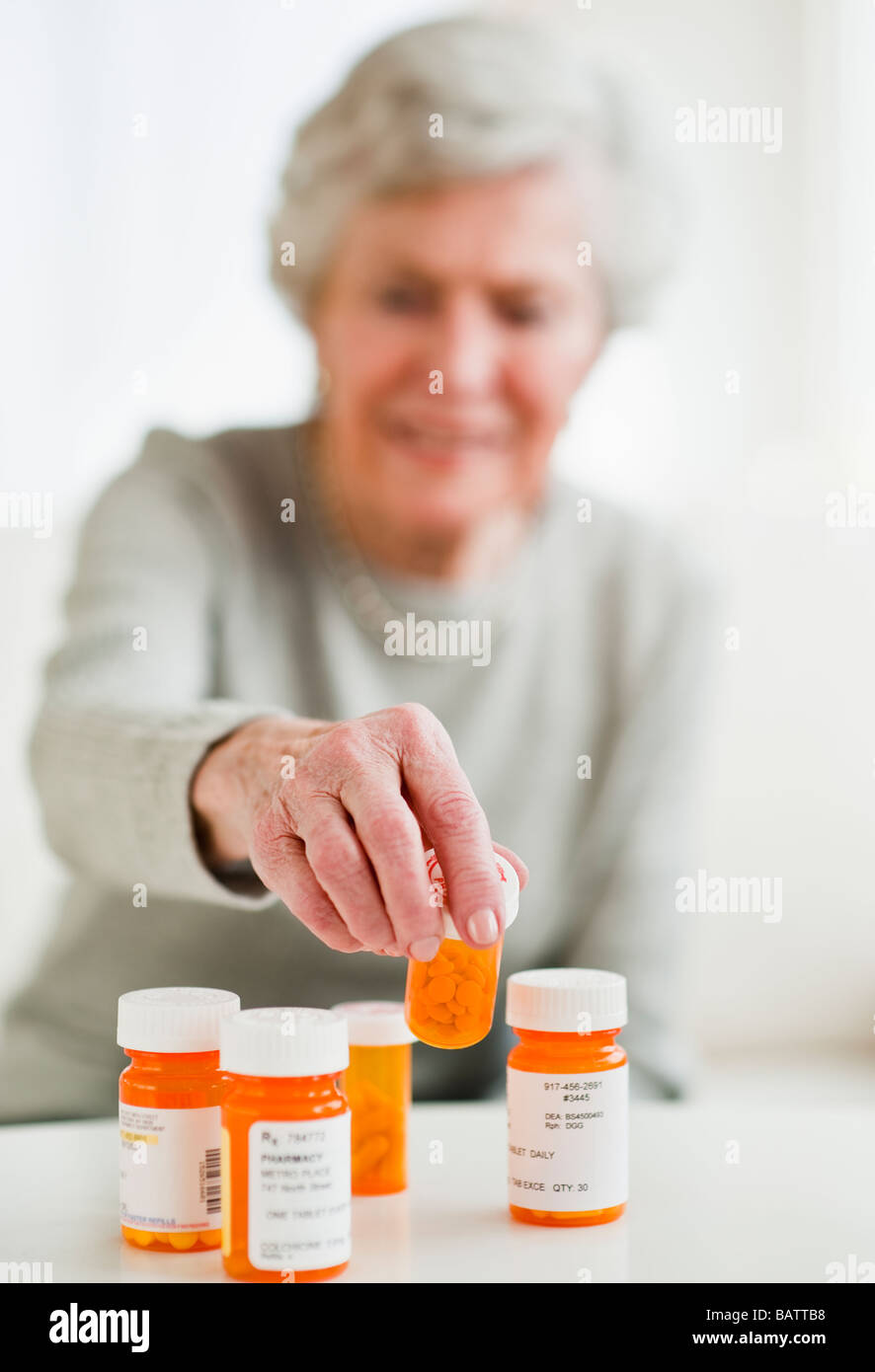 Donna senior di prelevare la pillola bottiglia Foto Stock