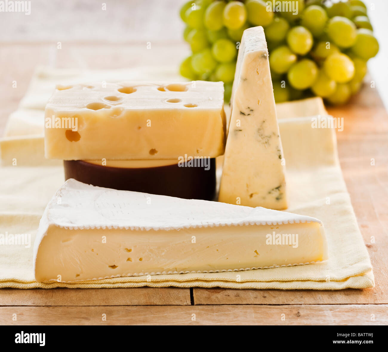 Pezzi di formaggio con uve sullo sfondo Foto Stock