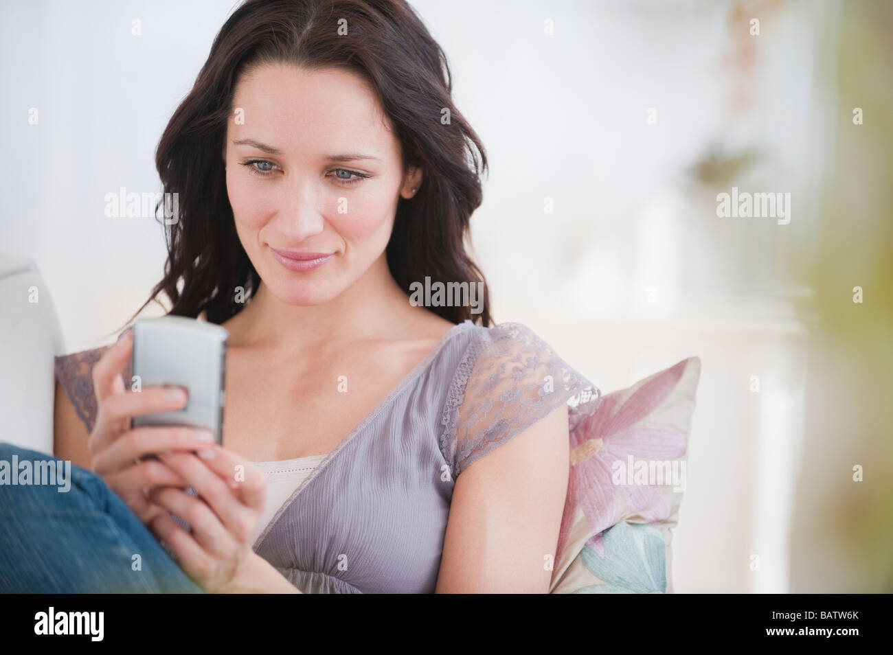 Donna della messaggistica di testo, sorridente Foto Stock