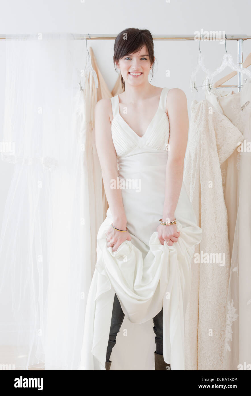 Ritratto di giovane donna che indossa abiti da sposa in negozio Foto stock  - Alamy