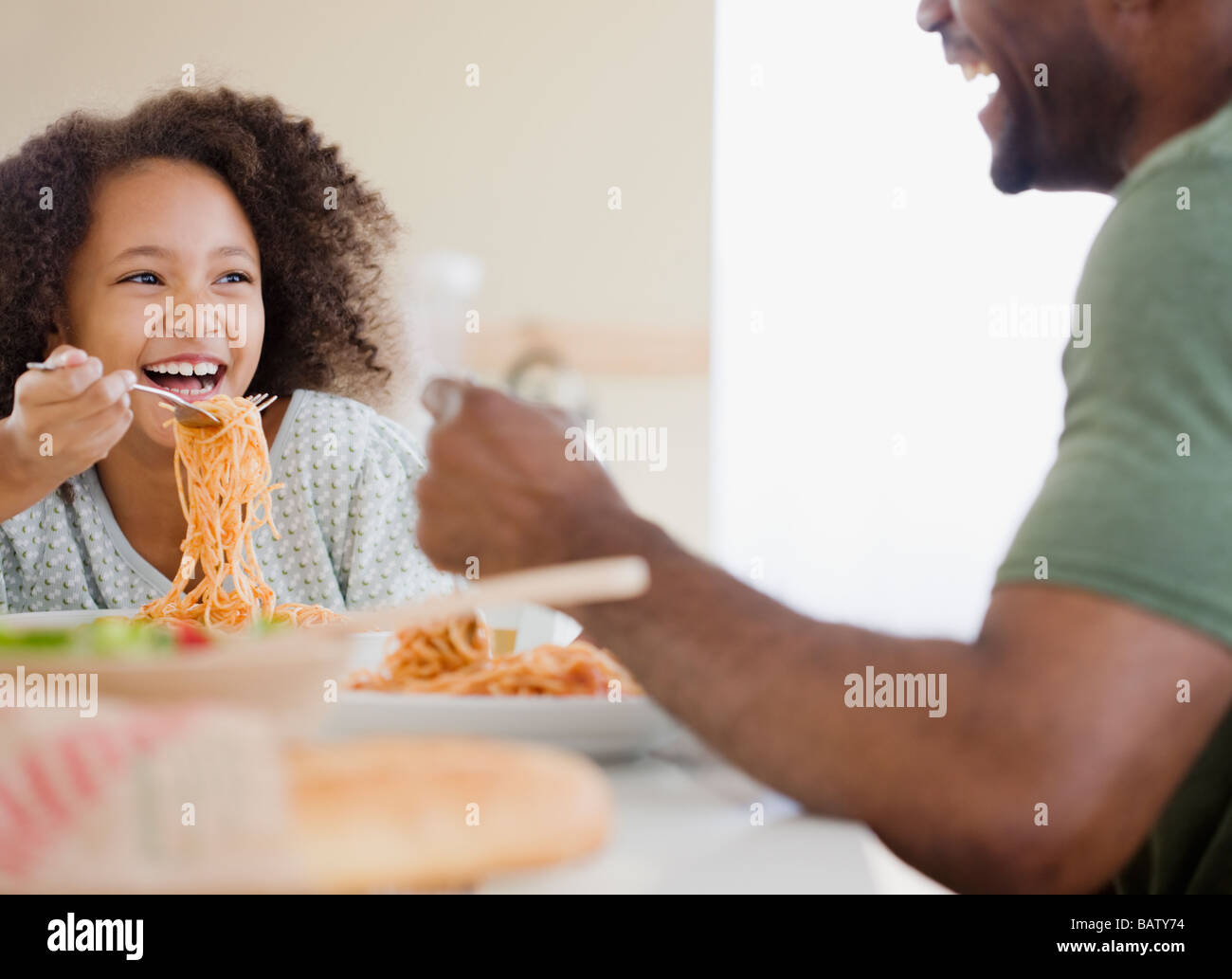 African padre e figlia mangiare pasta Foto Stock