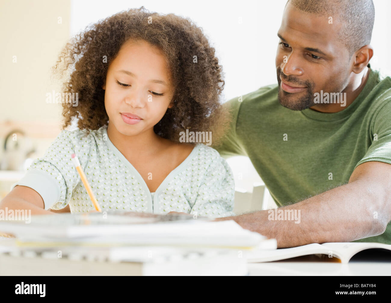 Padre africane aiutando la figlia con i compiti Foto Stock