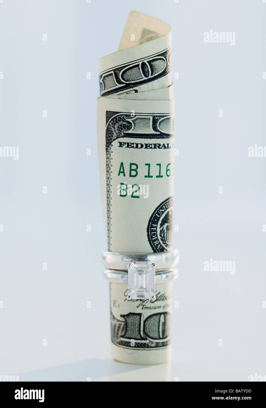 Un centinaio di dollari arrotolato in anello di nozze Foto Stock