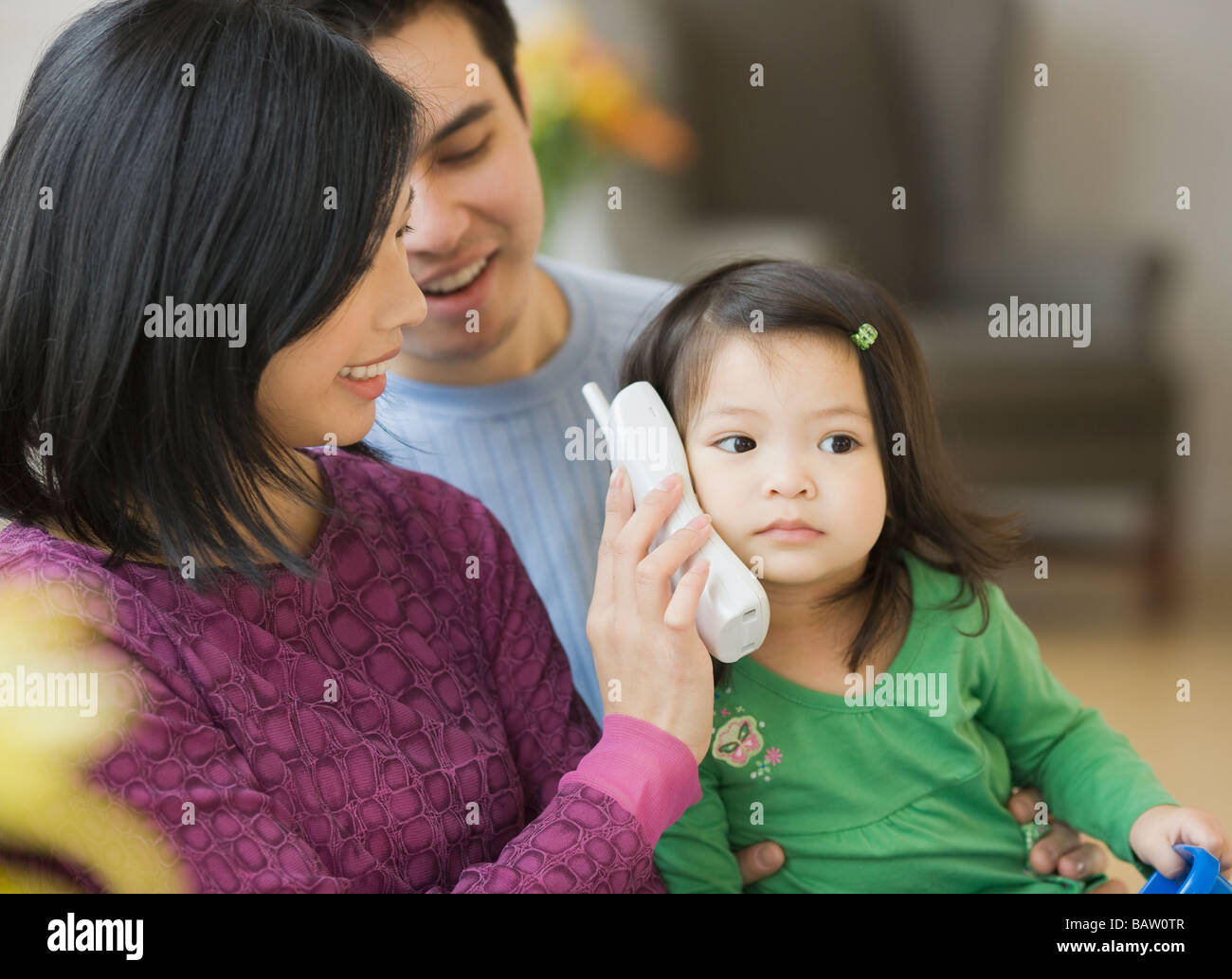 Il padre e la madre tenendo il telefono per la figlia di Foto Stock