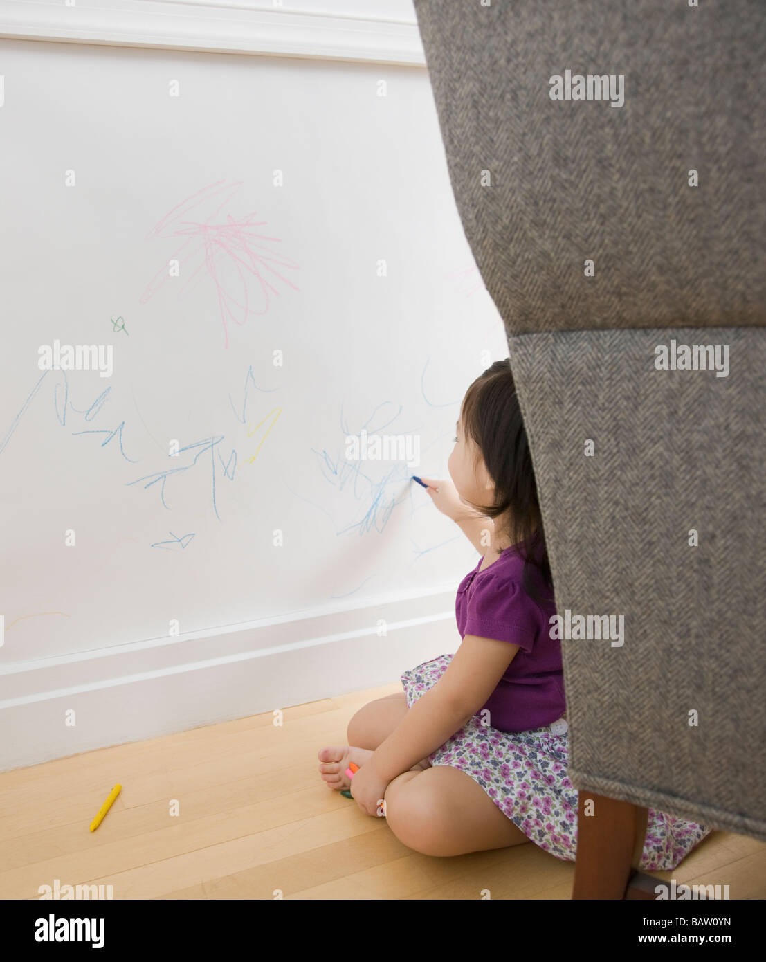 Il Toddler girl disegno sulla parete con matite colorate Foto Stock
