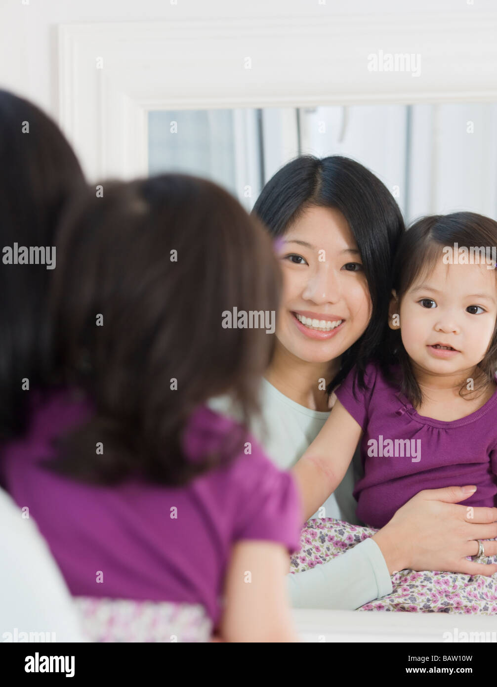 Madre e figlia cercando in specchio Foto Stock