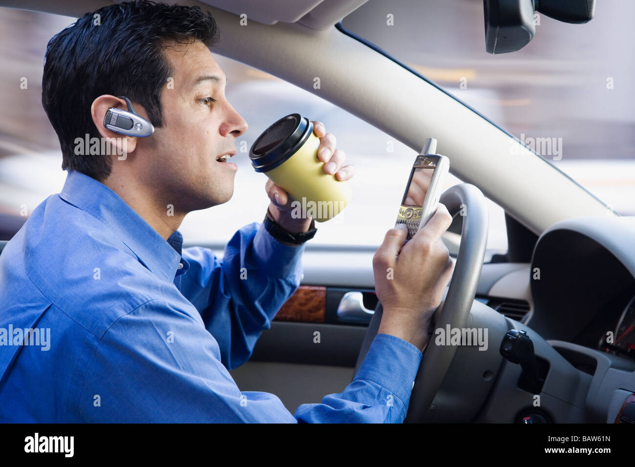 Imprenditore ispanica tramite telefono cellulare a bere caffè e la guida Foto Stock