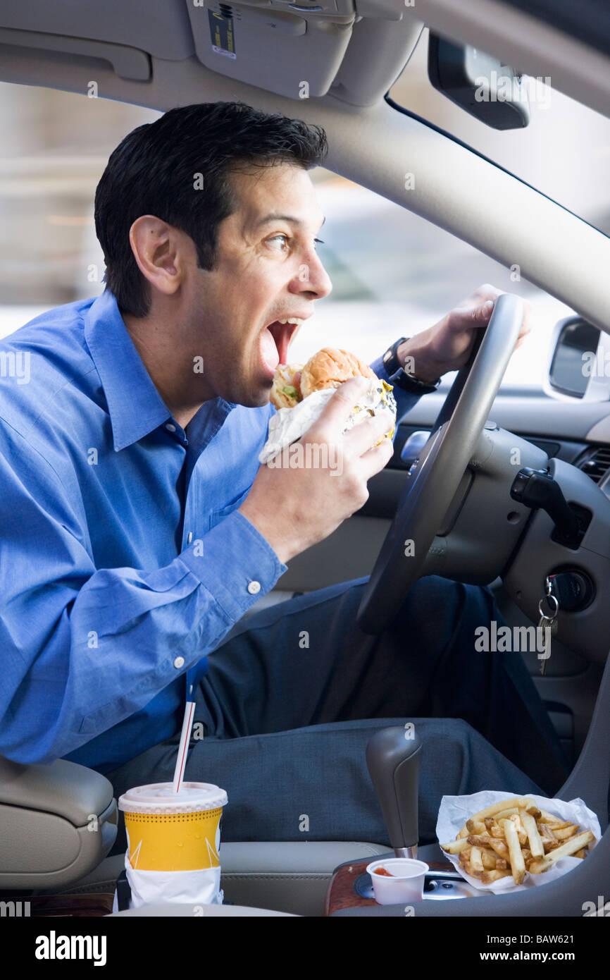 Imprenditore ispanica di mangiare e la guida Foto Stock