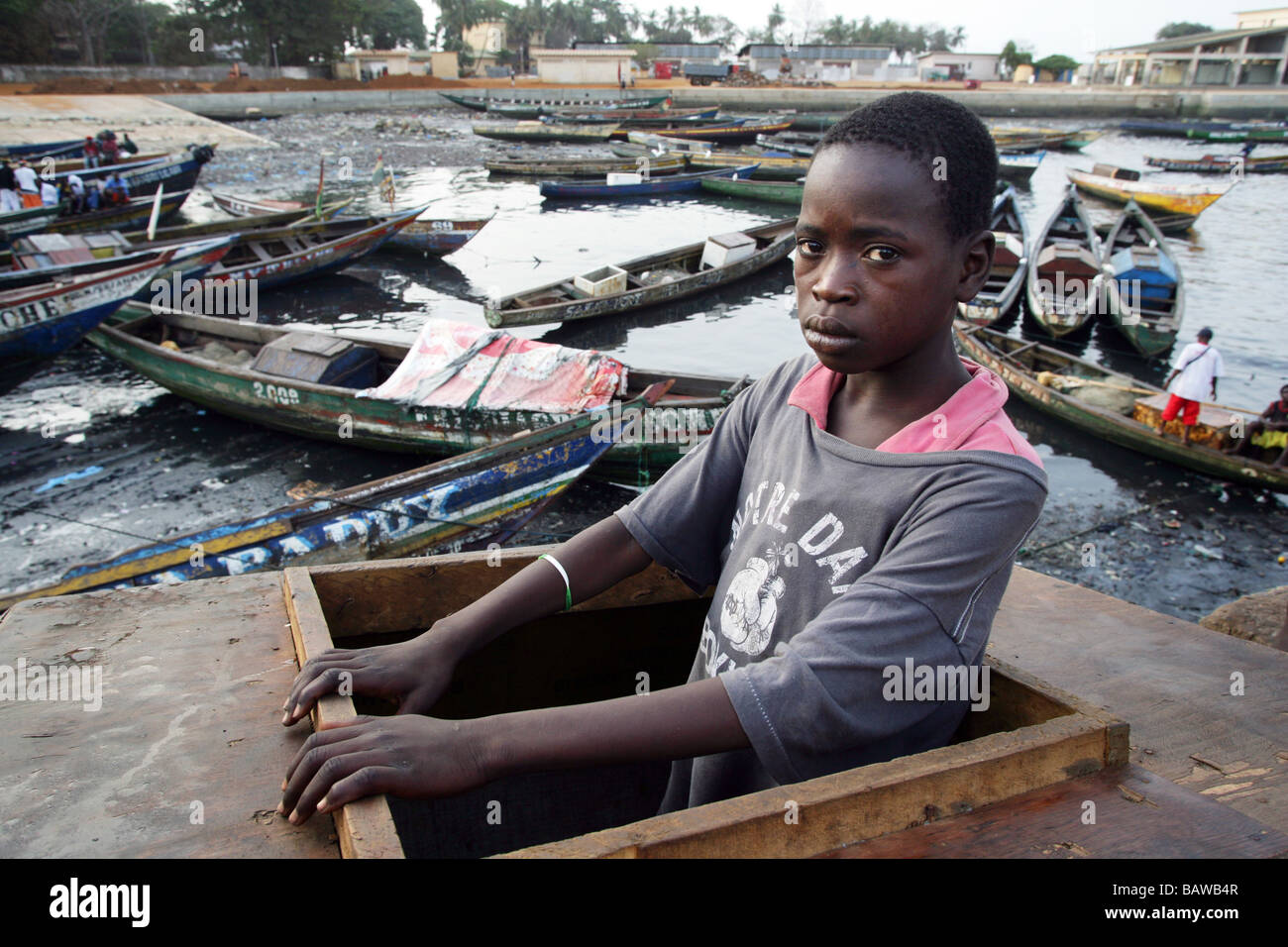 Guinea Conakry: streetkid nella sua sleepingplace in una scatola di legno al fishingport di Conacry Foto Stock
