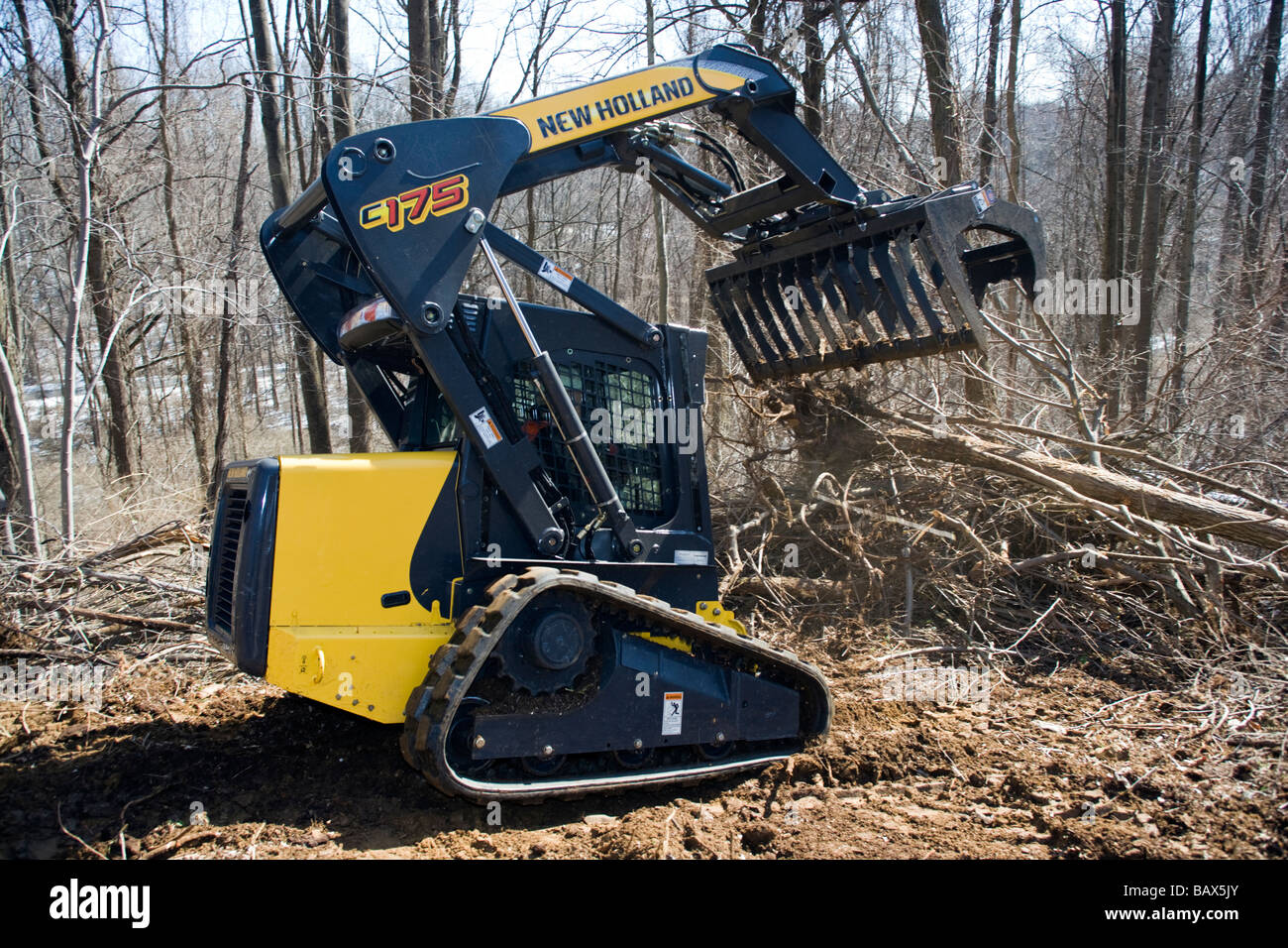 New Holland C 175 tracked minipala caricatrice spazzola di compensazione su un lotto residenziale Foto Stock