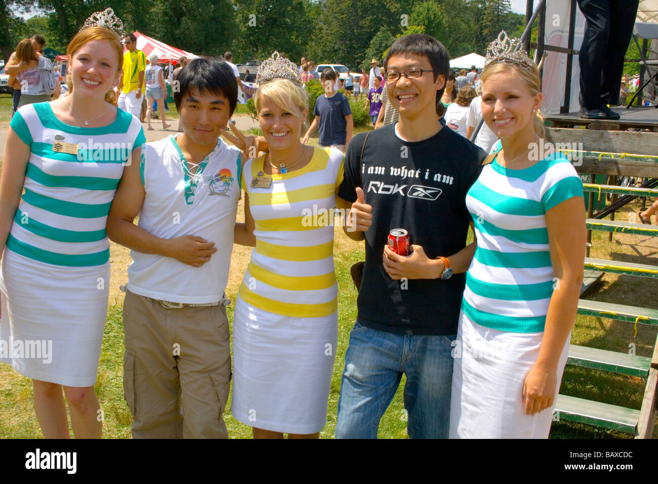 Visitatori asiatici divertendosi con Aquatennial queens. Spiaggia Aquatennial Bash Minneapolis Minnesota USA Foto Stock Visitatori asiatici divertendosi con Aquatennial queens. Spiaggia Aquatennial Bash Minneapolis Minnesota USA Foto Stock
