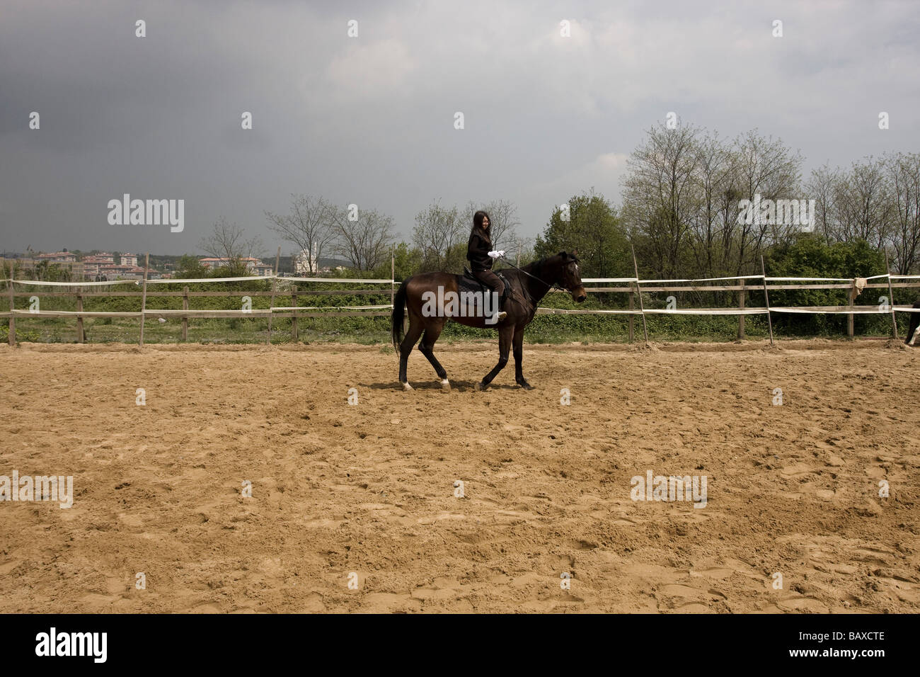 È una ragazza in sella ad un cavallo al maneage Foto Stock